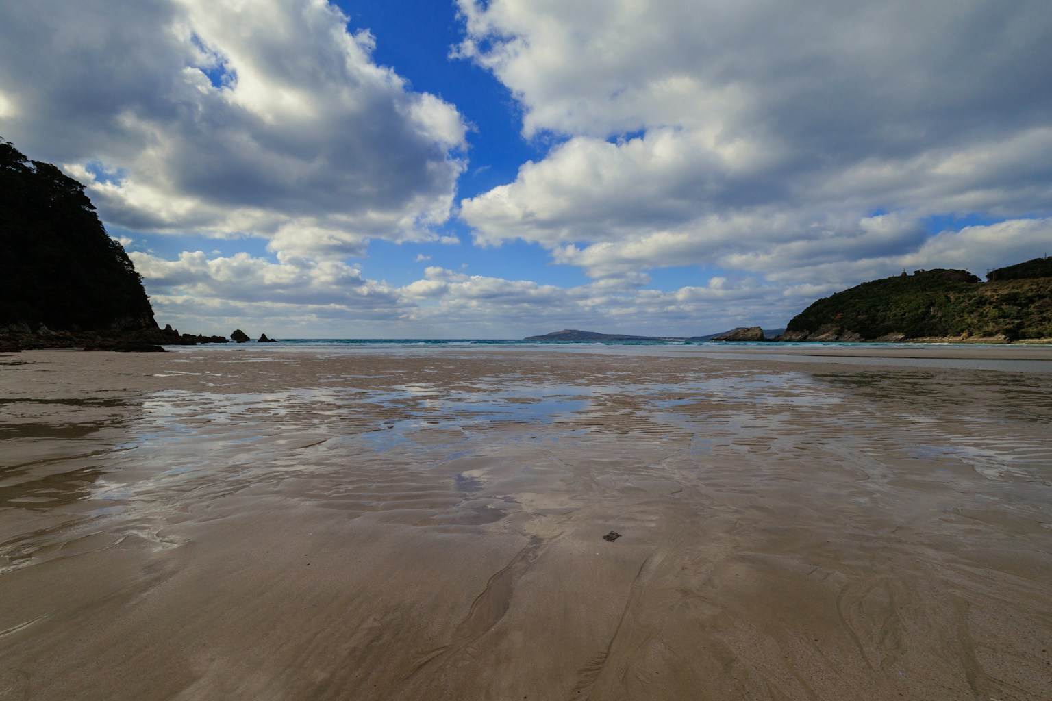 Beach landscape with blue sky and clouds sand and water reflections