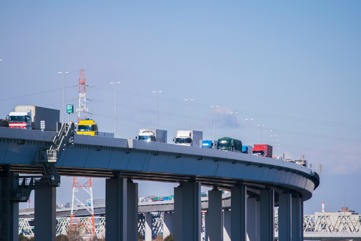 Una vista di un'autostrada con camion che circolano sotto un cielo blu