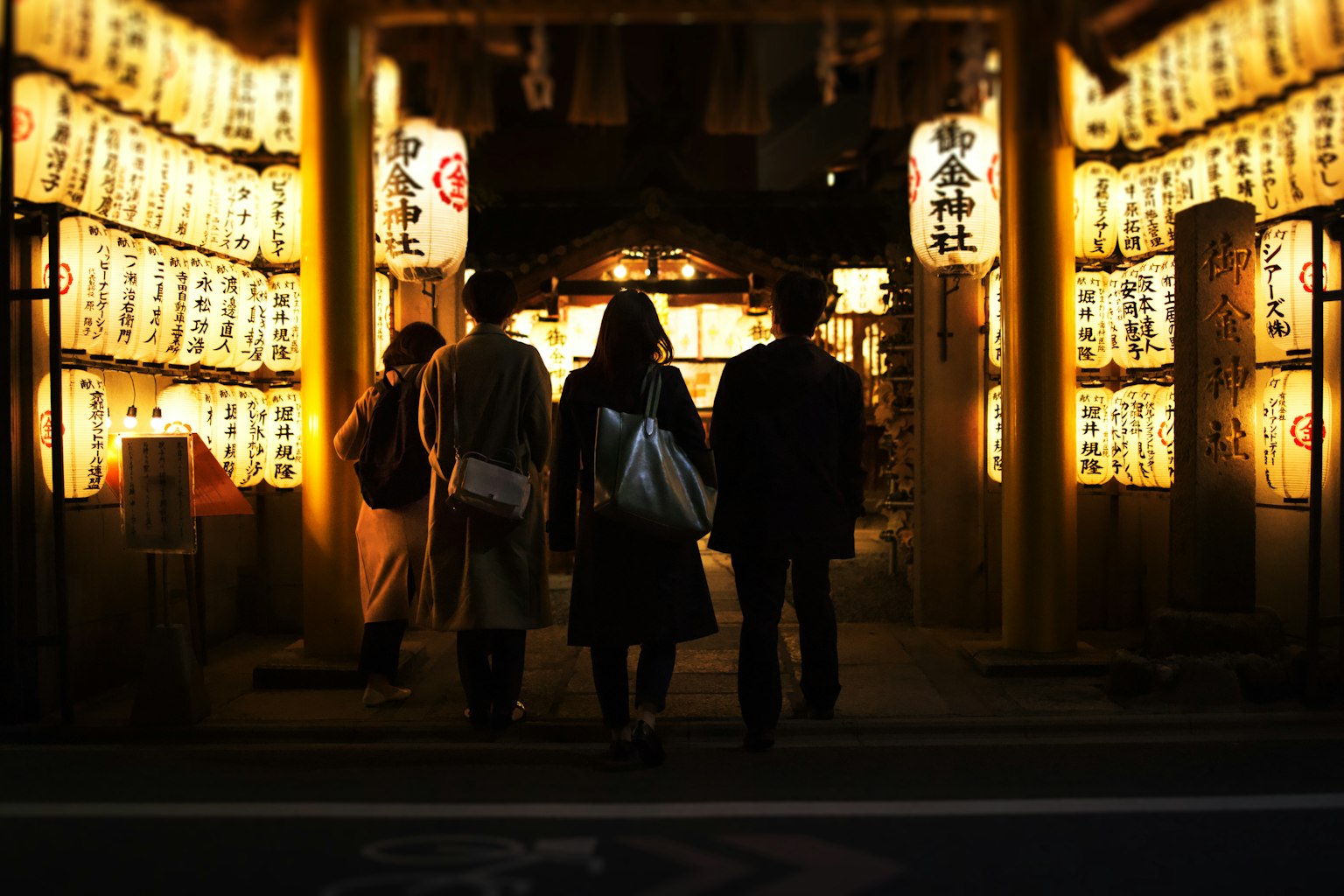 夜晚走在发光灯笼前的人们的轮廓