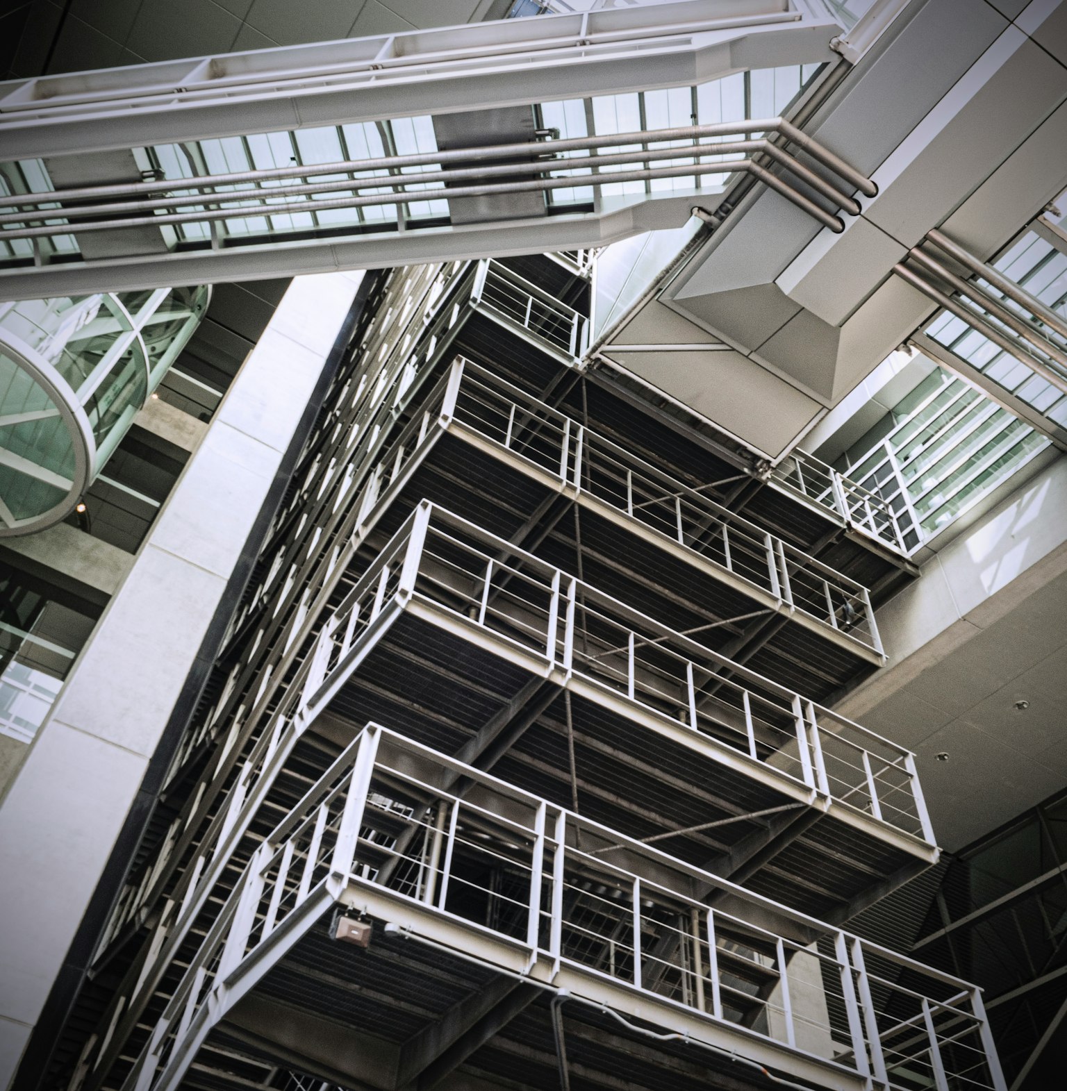 Imagen que muestra la estructura interior de un edificio moderno con escaleras y barandillas de metal