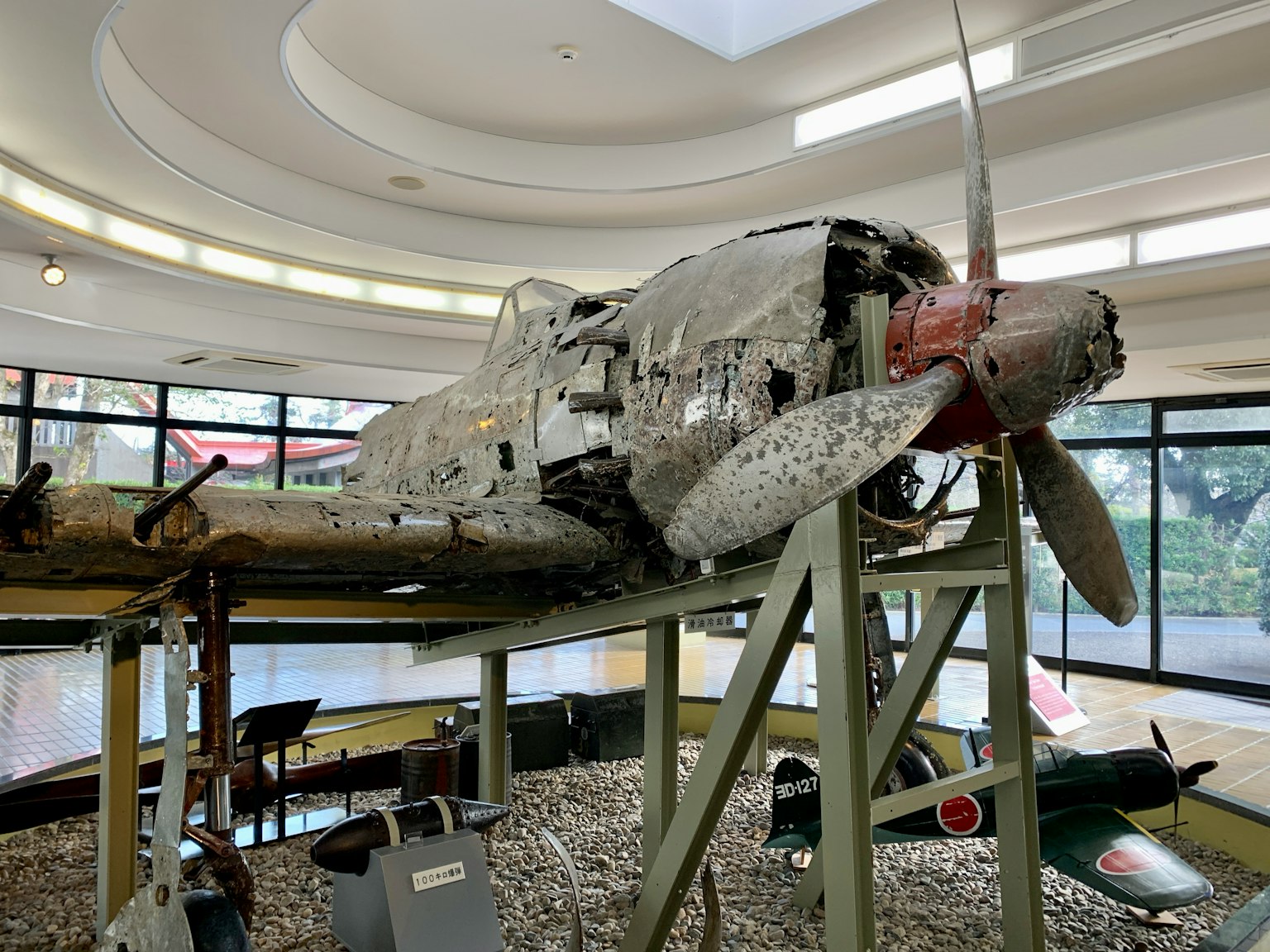 Remains of an old aircraft displayed in a museum with visible propeller