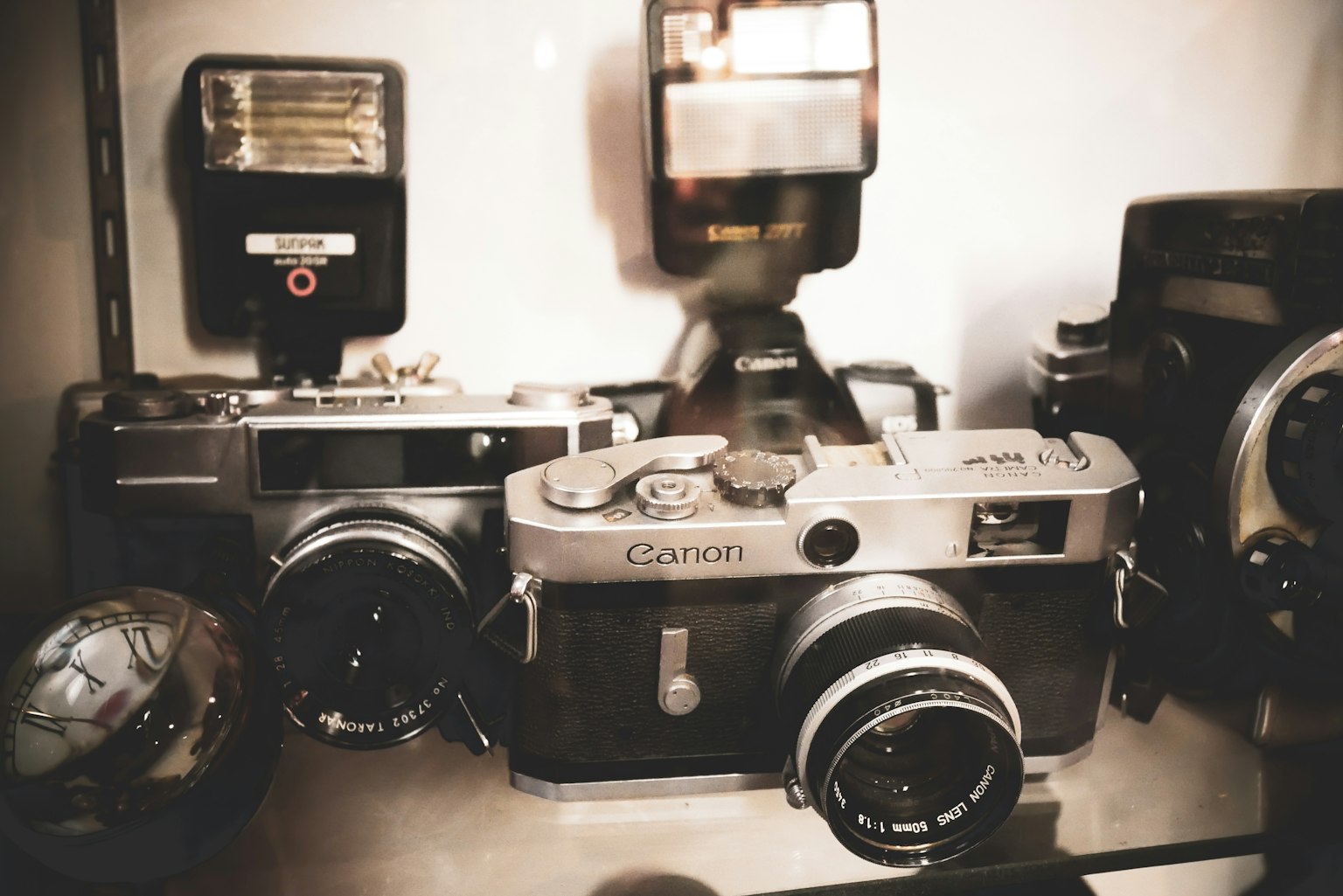 Appareils photo vintage et unités de flash exposés sur une étagère