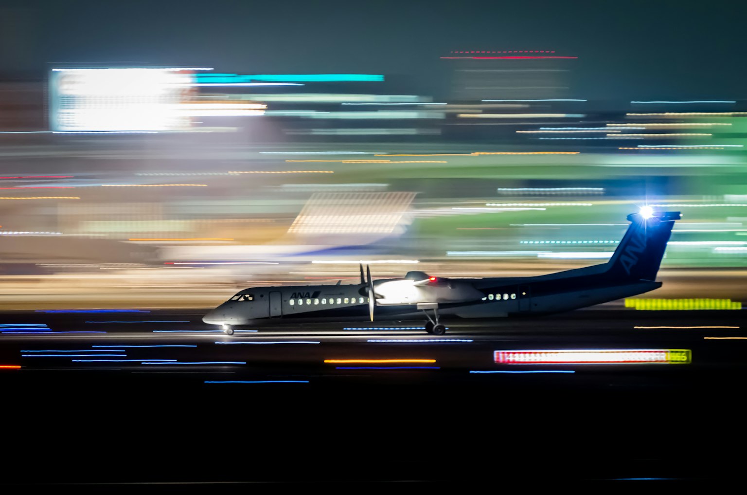 Bild eines kleinen Passagierflugzeugs, das nachts mit Bewegungsunschärfe startet