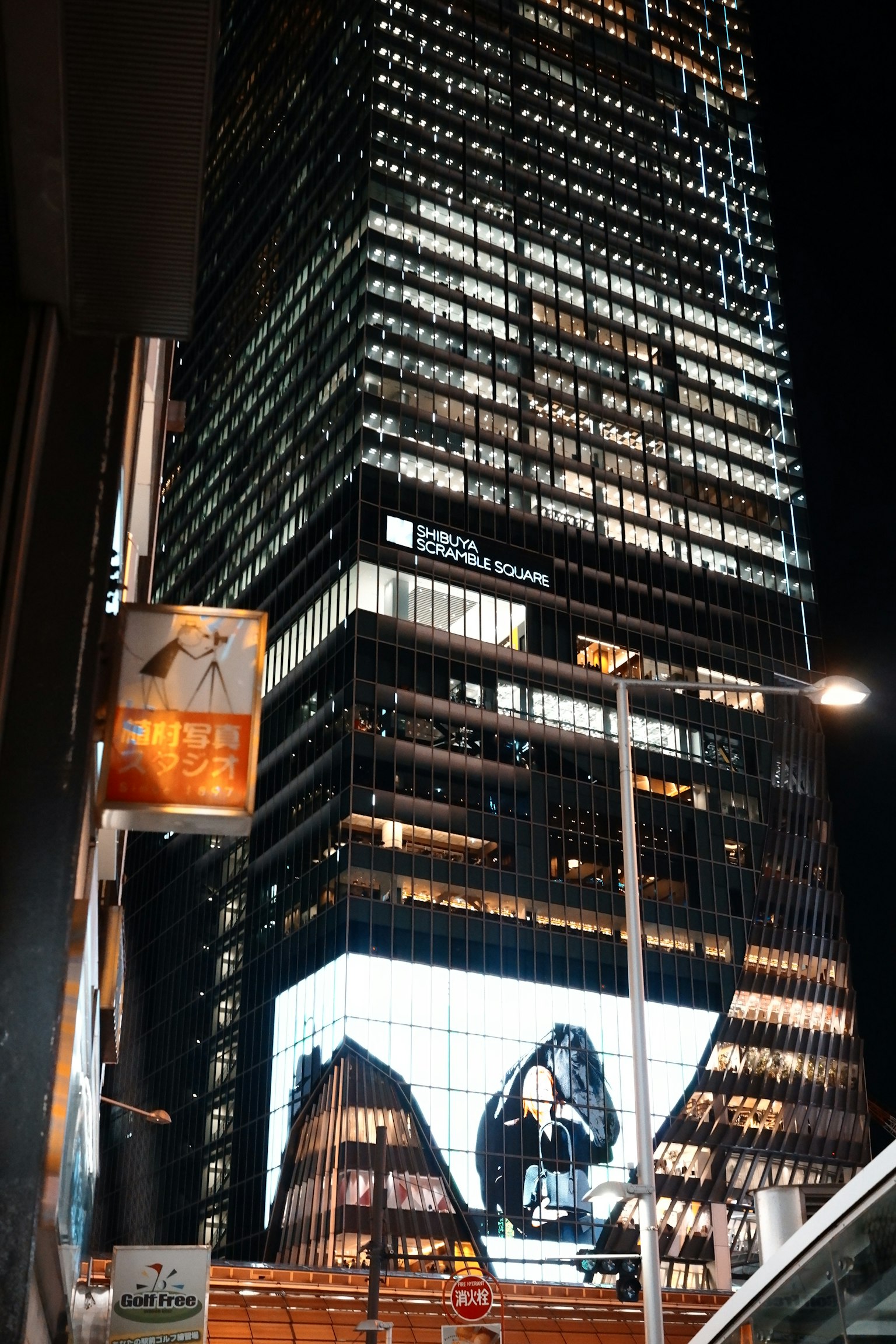 夜间城市景观，高楼大厦和展示广告的大型LED屏幕