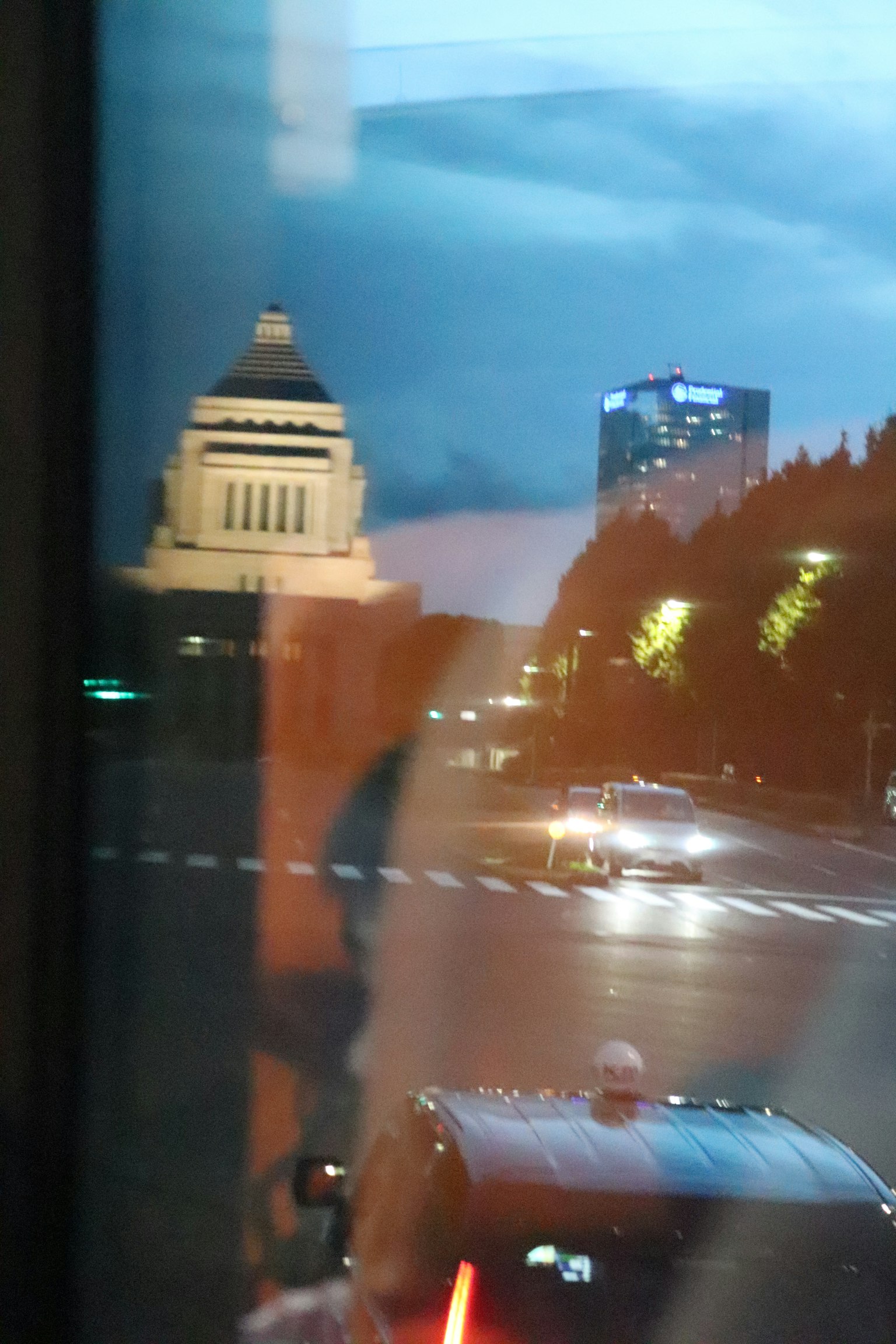 Night cityscape with the National Diet Building reflected in a window