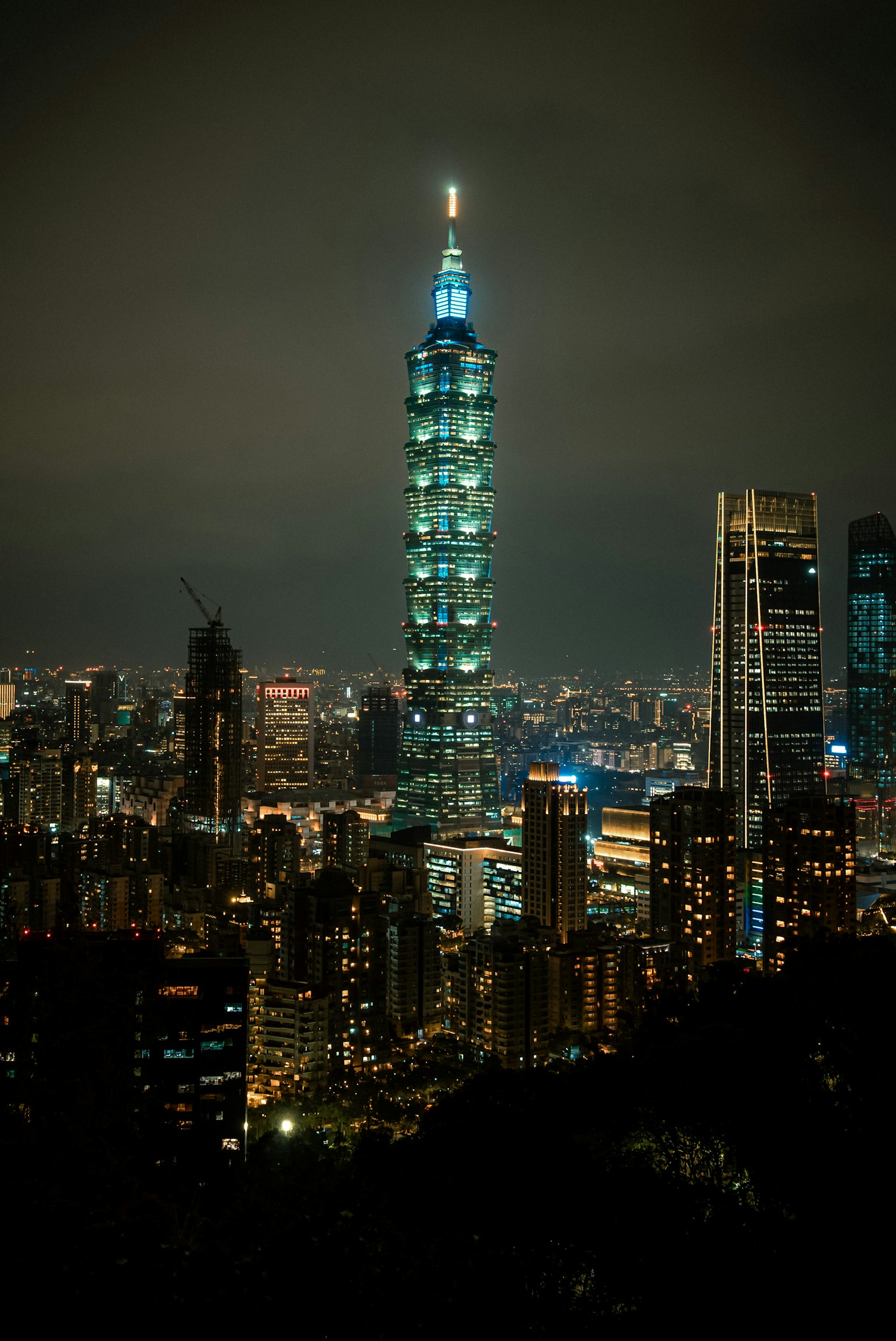 Taipei 101 illuminato di notte con uno skyline urbano vibrante