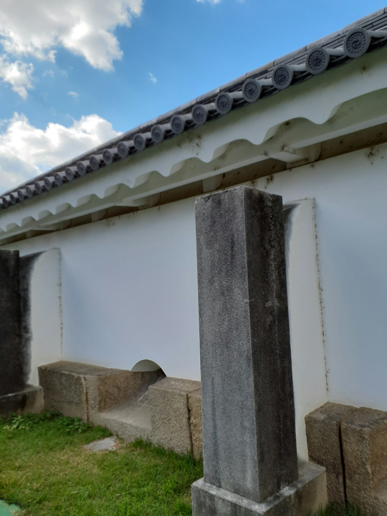 在藍天下，傳統建築的側面，白色牆壁和石柱