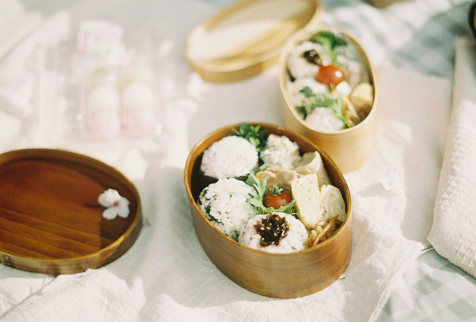 Hidangan berwarna-warni disusun dalam kotak makan siang bambu