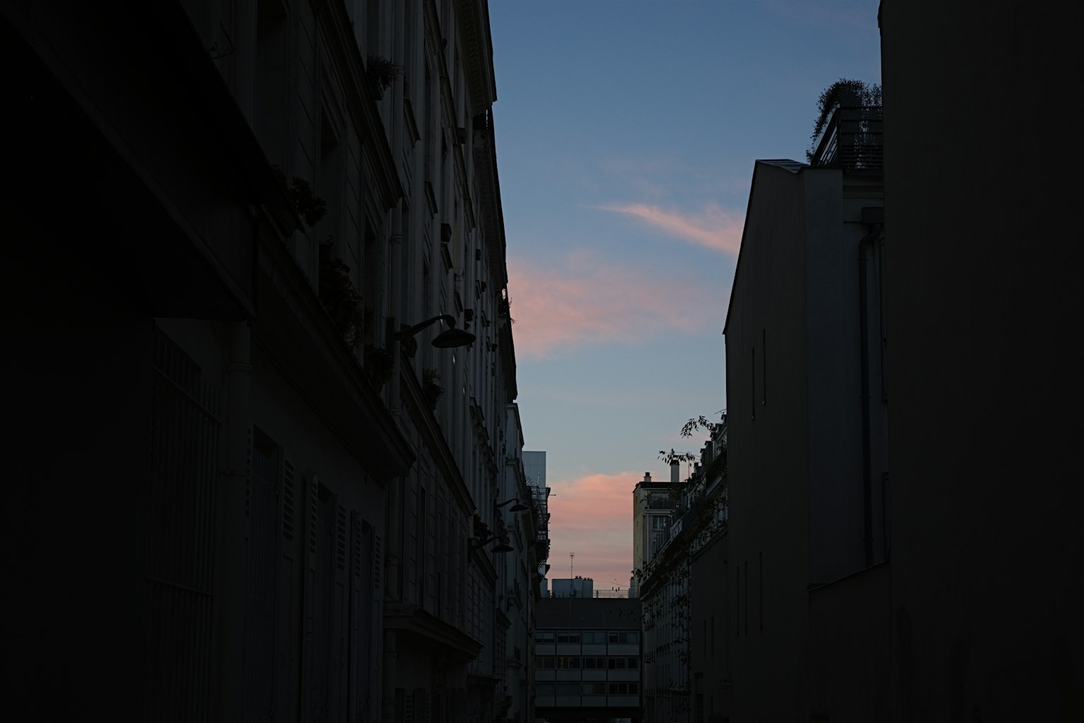 Silhouette of narrow alley with sunset sky