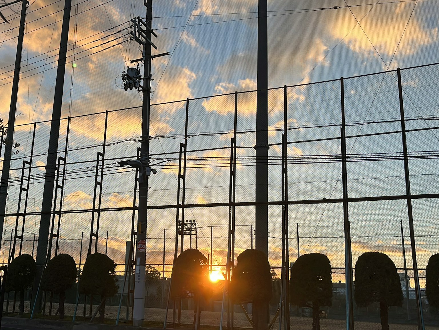 Silhouette eines Zauns mit Sonnenuntergang im Hintergrund