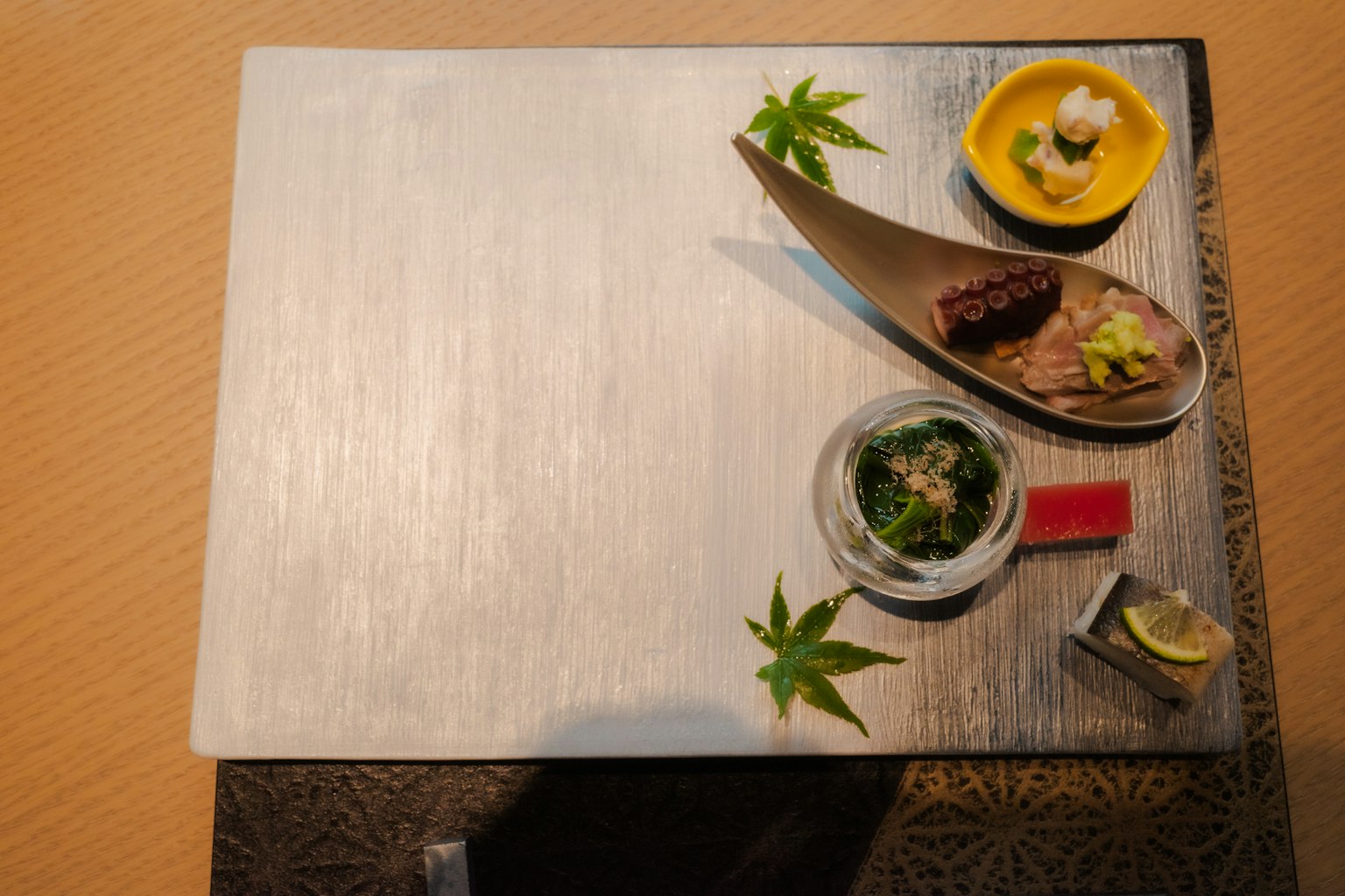 Eine elegante Präsentation der japanischen Küche auf einem Tisch mit kleinen Schalen und grünen Blättern