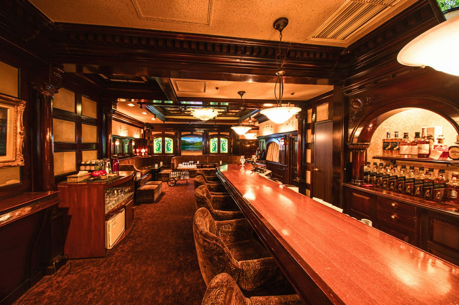 Intérieur de bar élégant avec comptoir en bois et éclairage luxueux dans une ambiance chaleureuse