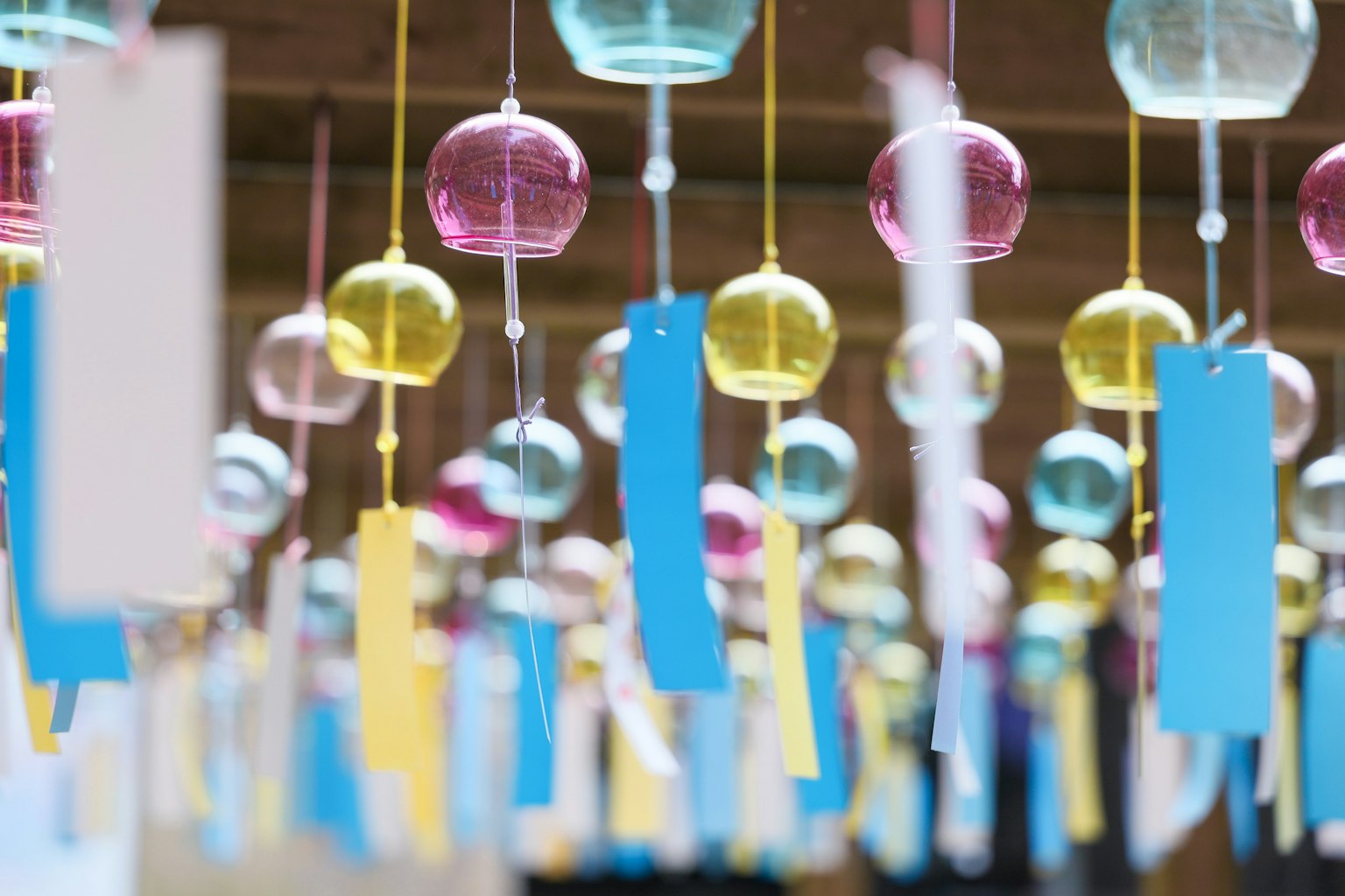 Bunte Windspiele und Tanzaku hängen in einer lebhaften Ausstellung
