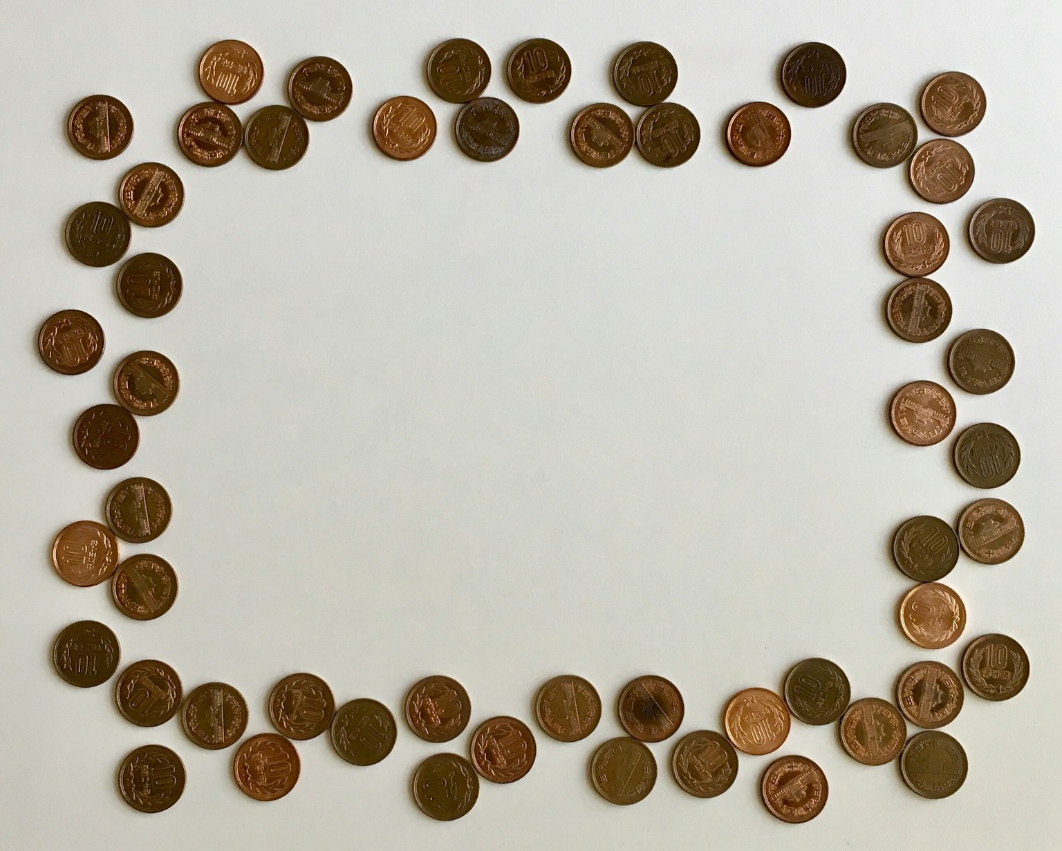Marco hecho de monedas dispuestas sobre un fondo blanco