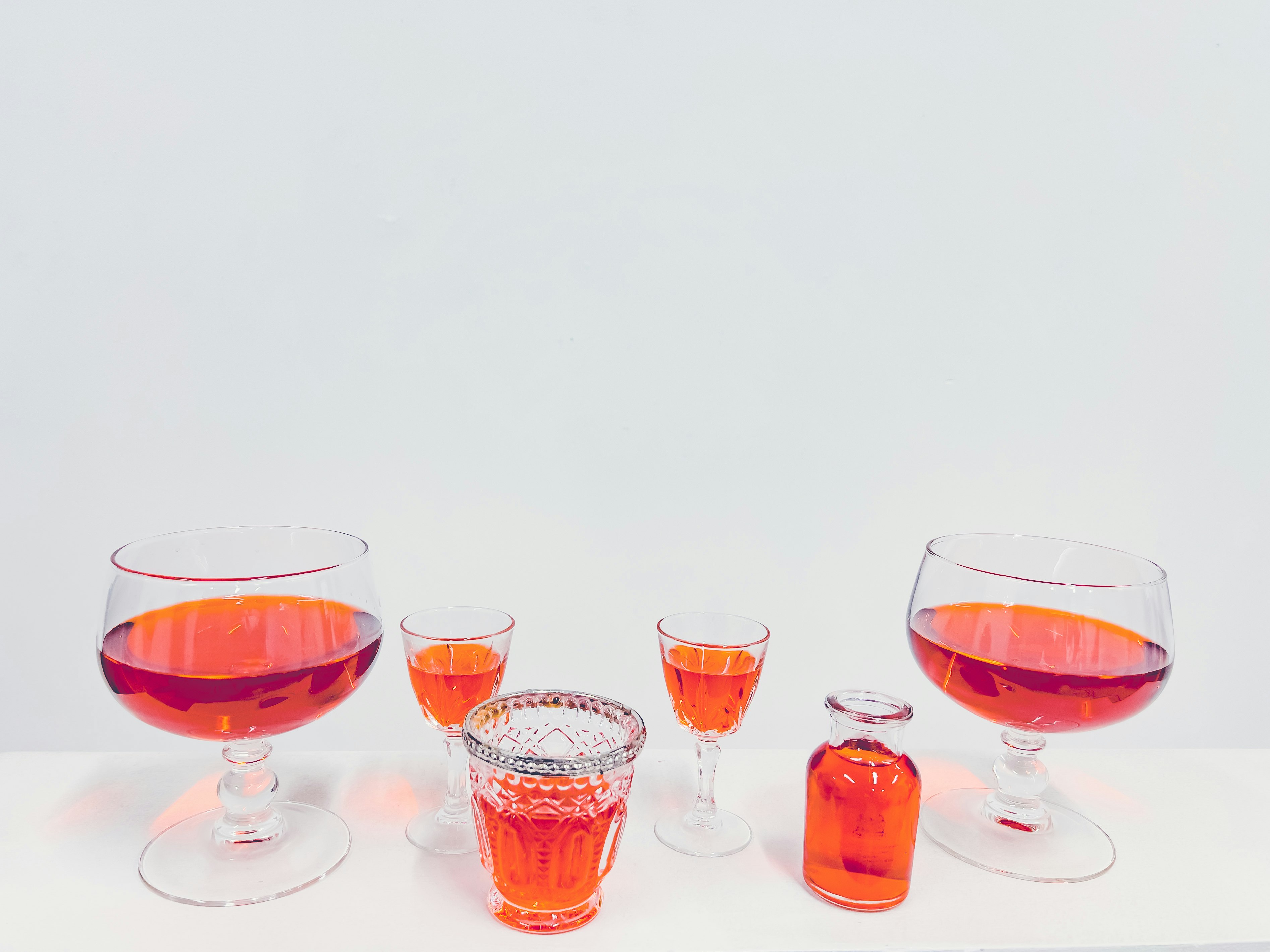 Tĩnh vật cocktail màu đỏ và ly trên nền trắng