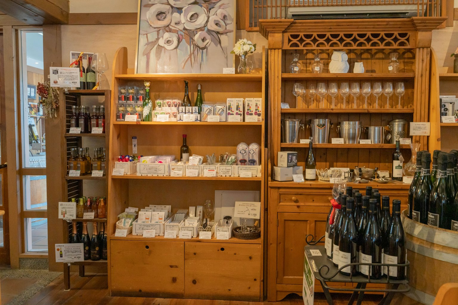 Vue intérieure d'un magasin avec des étagères en bois affichant des bouteilles de vin et divers produits