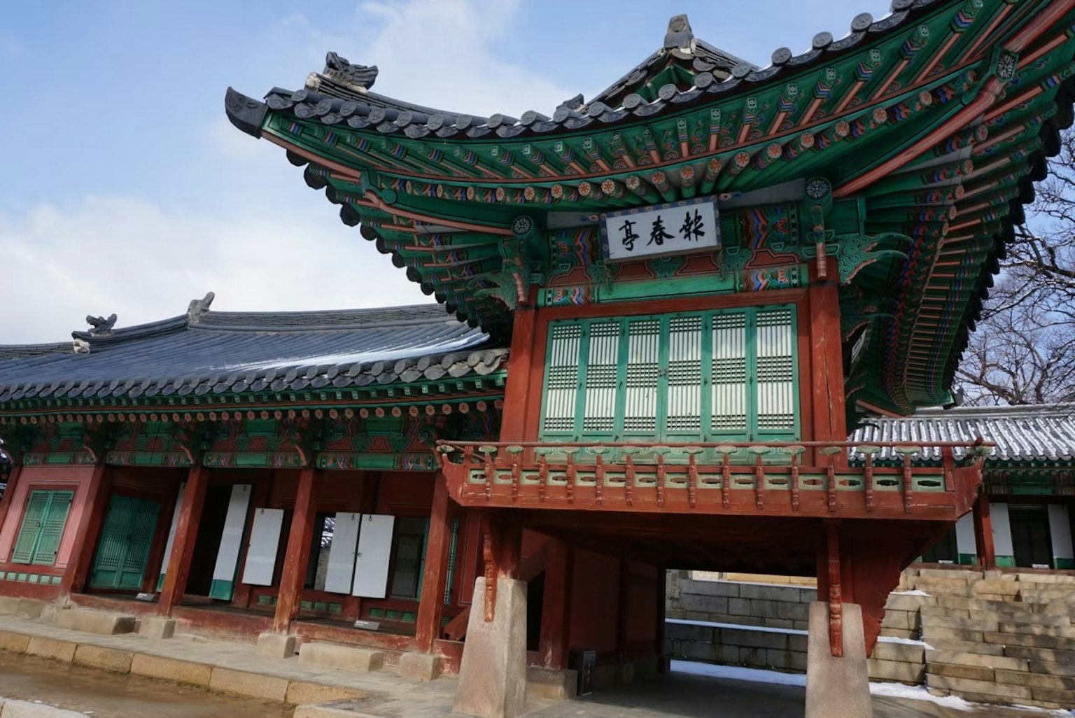 Belle façade d'un bâtiment traditionnel coréen avec un toit vert et rouge