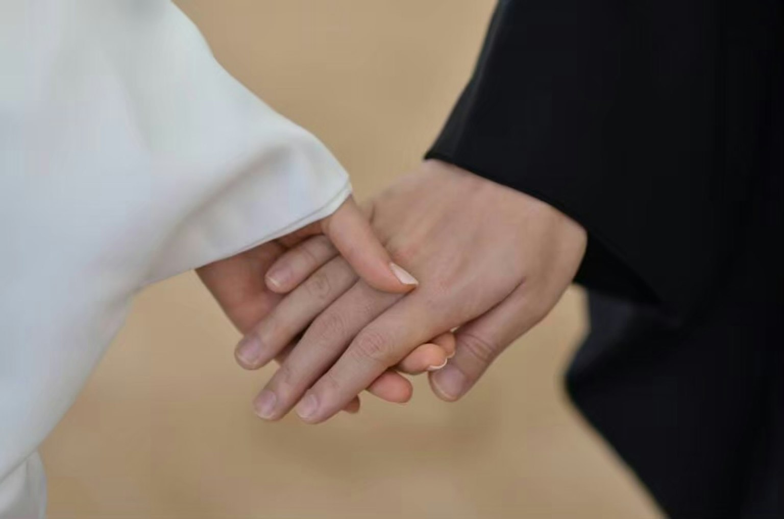 ภาพระยะใกล้ของมือสองข้างที่จับกัน