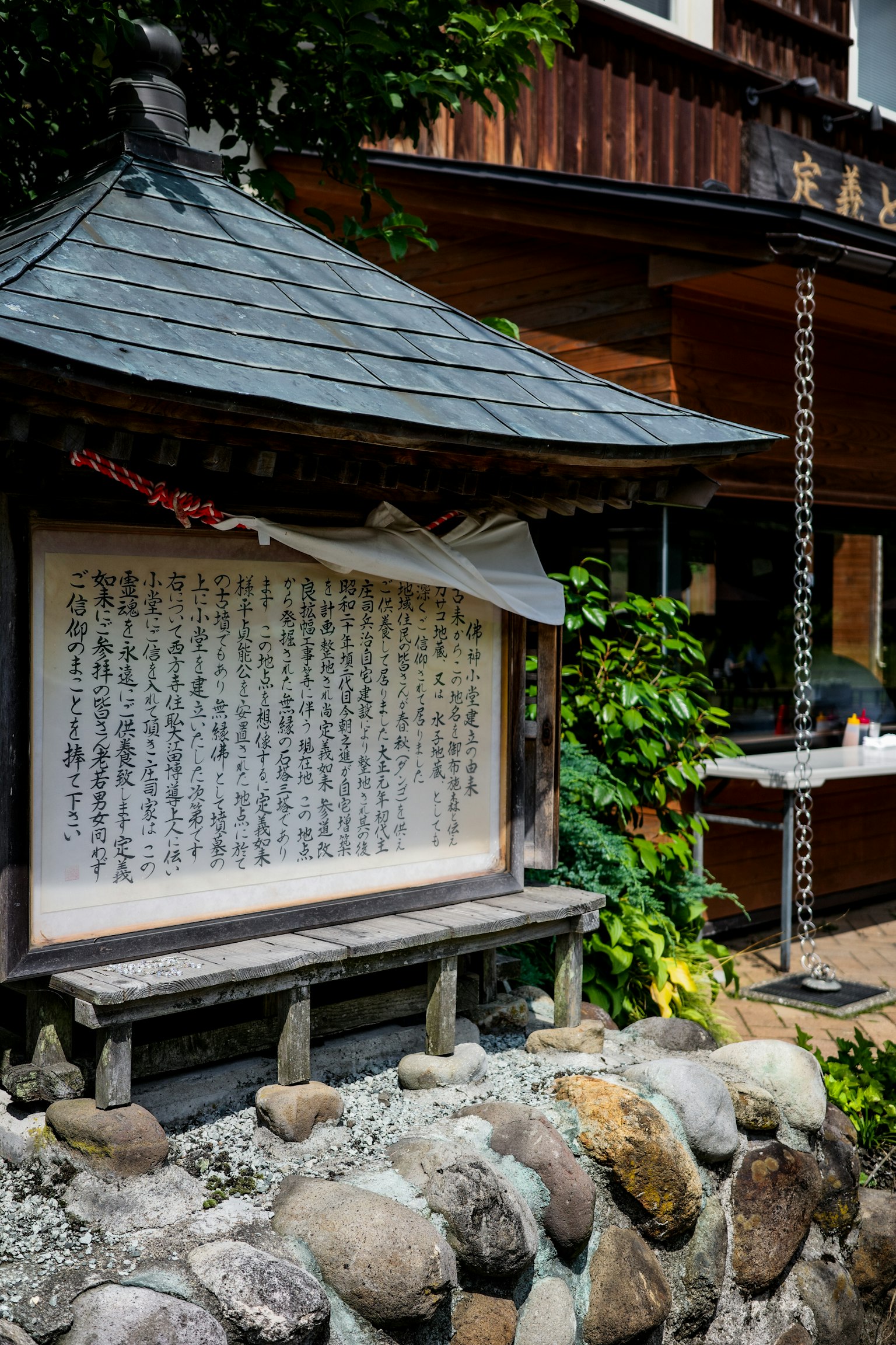 Foto eines traditionellen japanischen Gebäudes mit einer Steinmauer und einem Schild