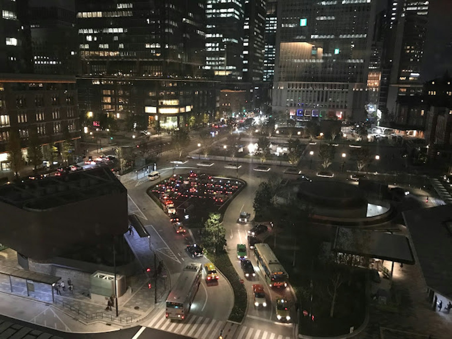 Night cityscape featuring skyscrapers and busy traffic intersection