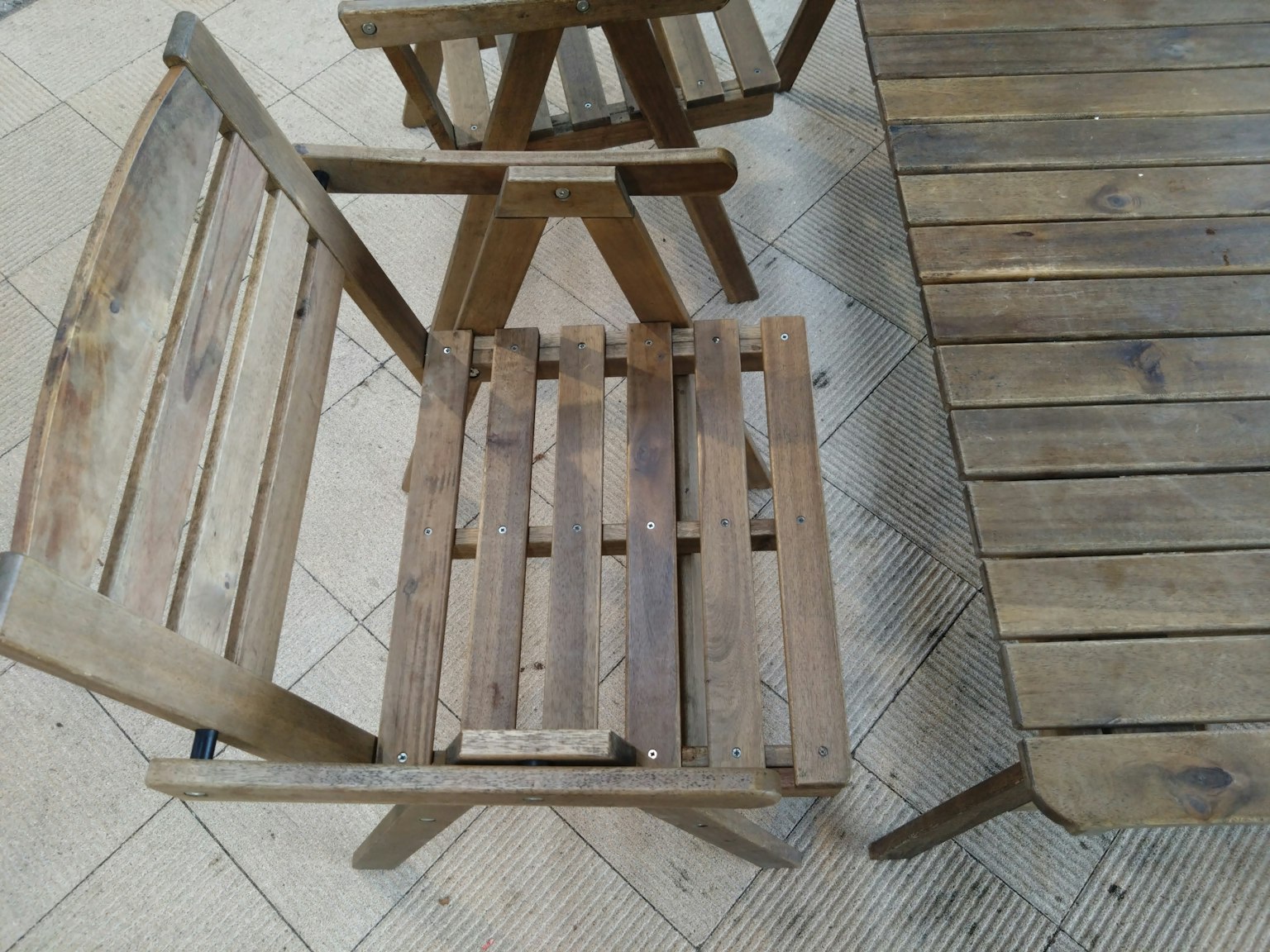 Wooden chairs and table arranged in an outdoor setting