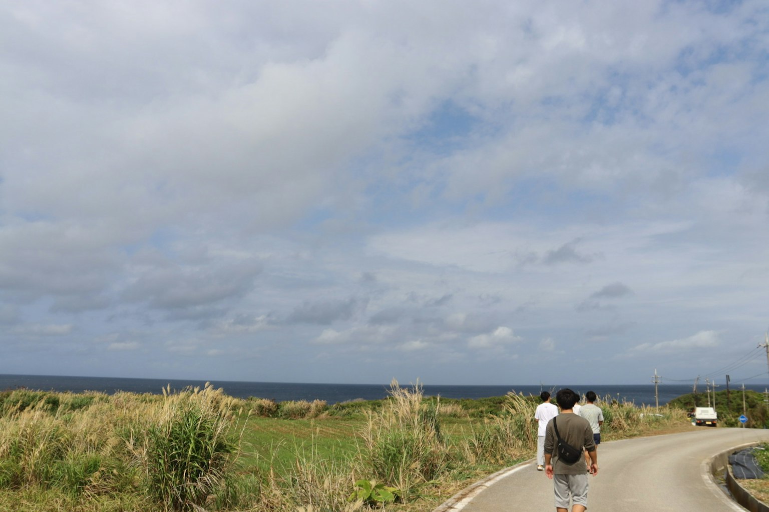 Menschen, die zum Meer gehen, mit einer grasbewachsenen Landschaft