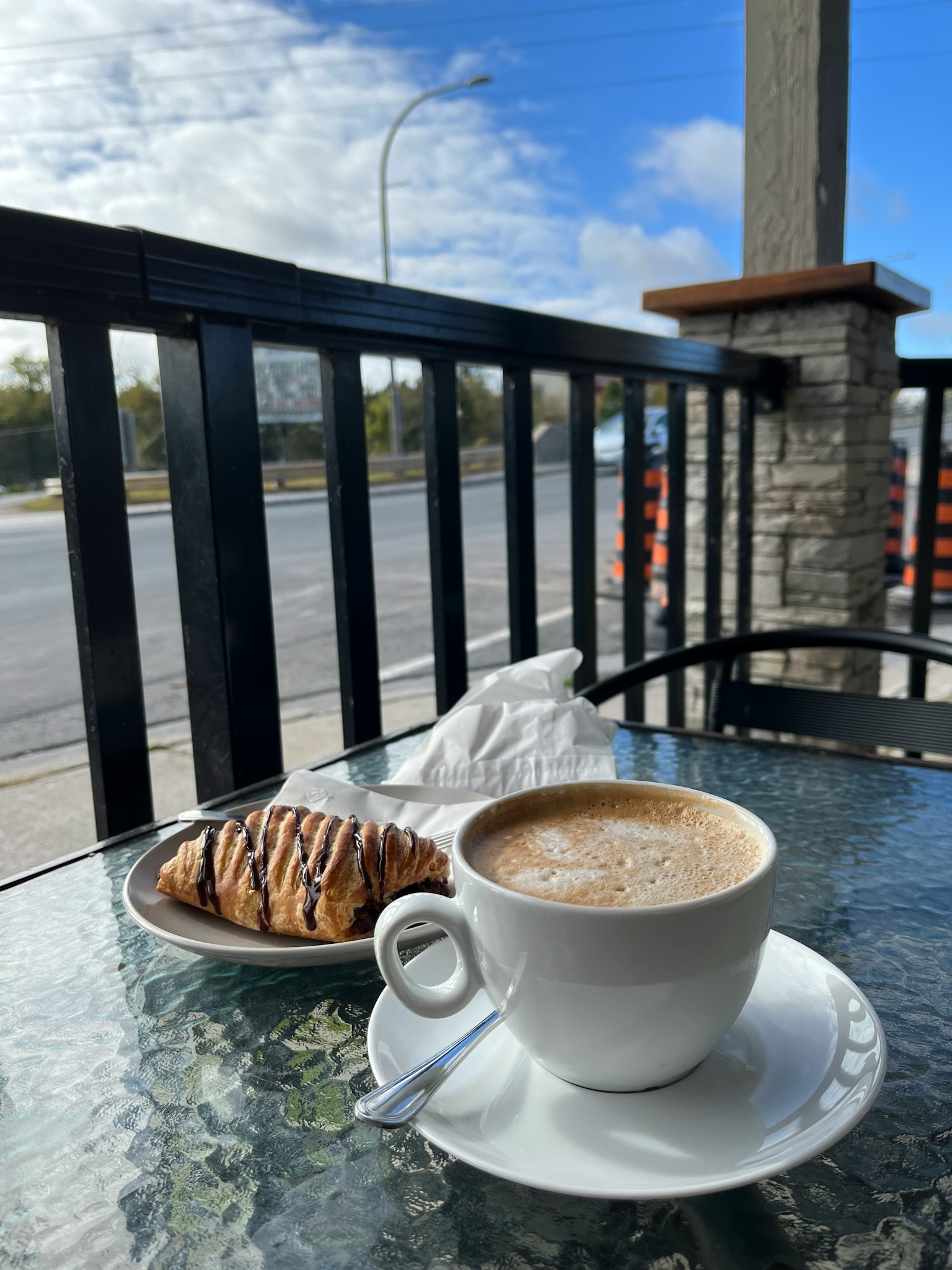 Una tazza di caffè e un dolce su un tavolo in un caffè all'aperto