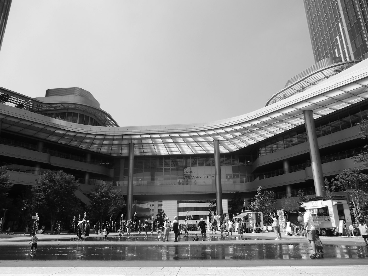 Schwarzweißfoto eines modernen Innenhofs voller Menschen