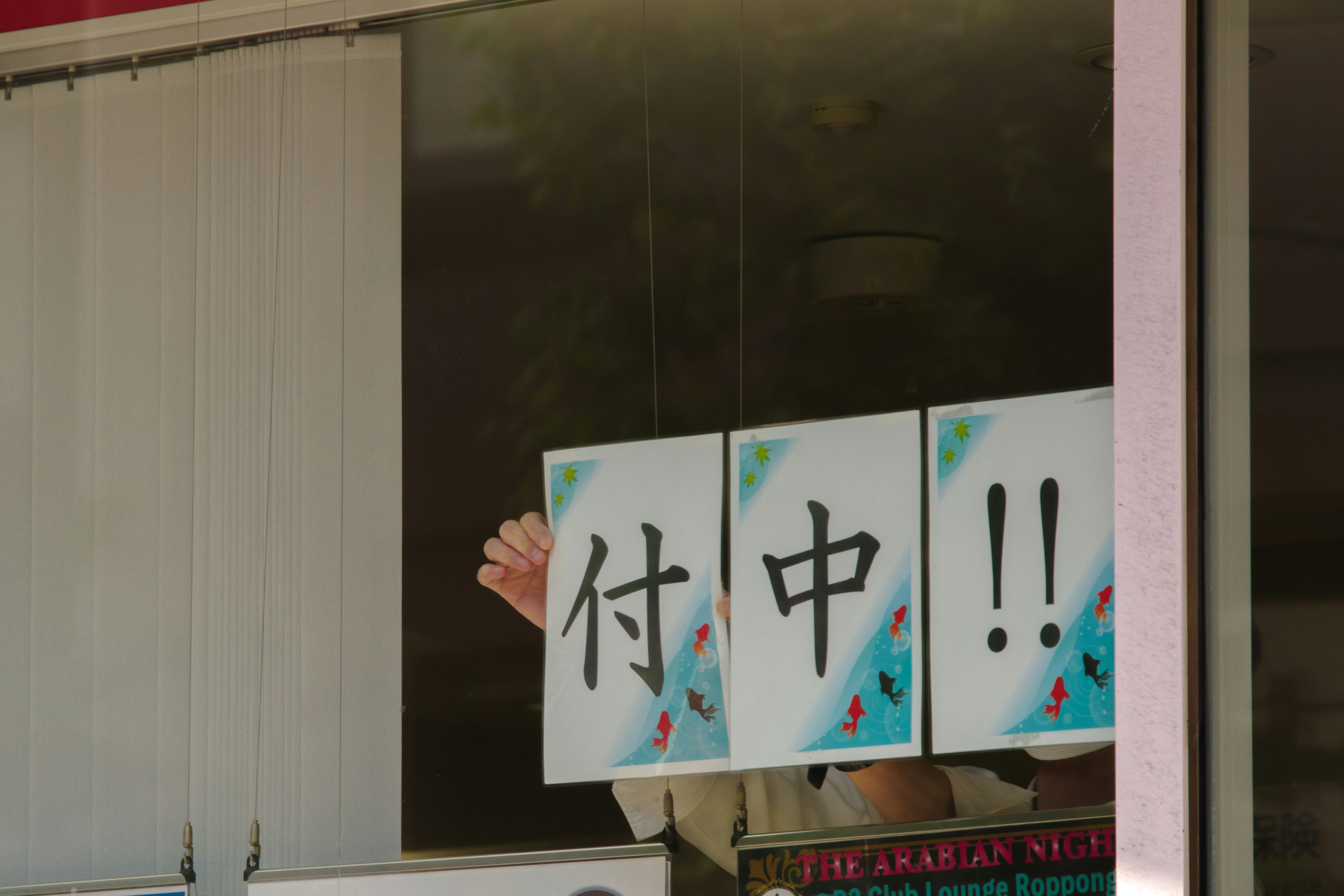 窗戶上貼著手寫告示紙，上面寫著「付中！！」