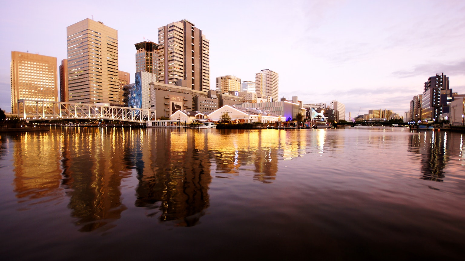 Horizonte de la ciudad reflejado en el agua al atardecer con rascacielos y arquitectura moderna