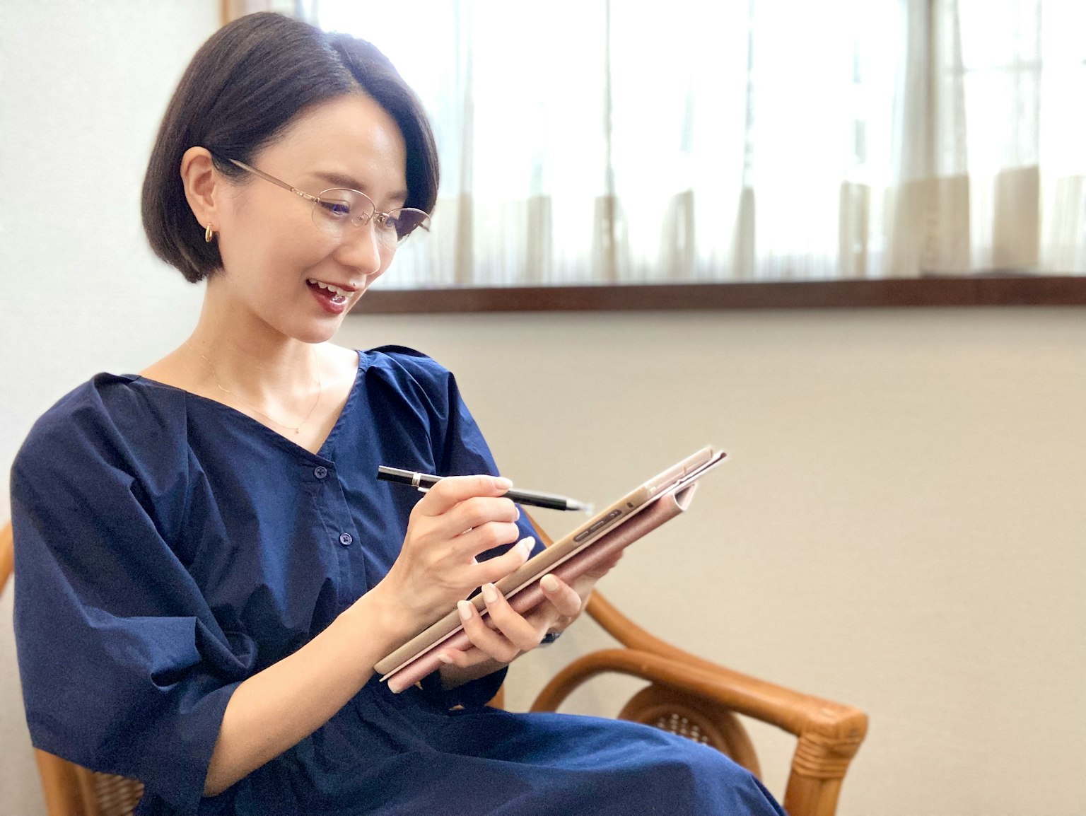 一位女性微笑著在平板上記筆記 明亮的自然光空間