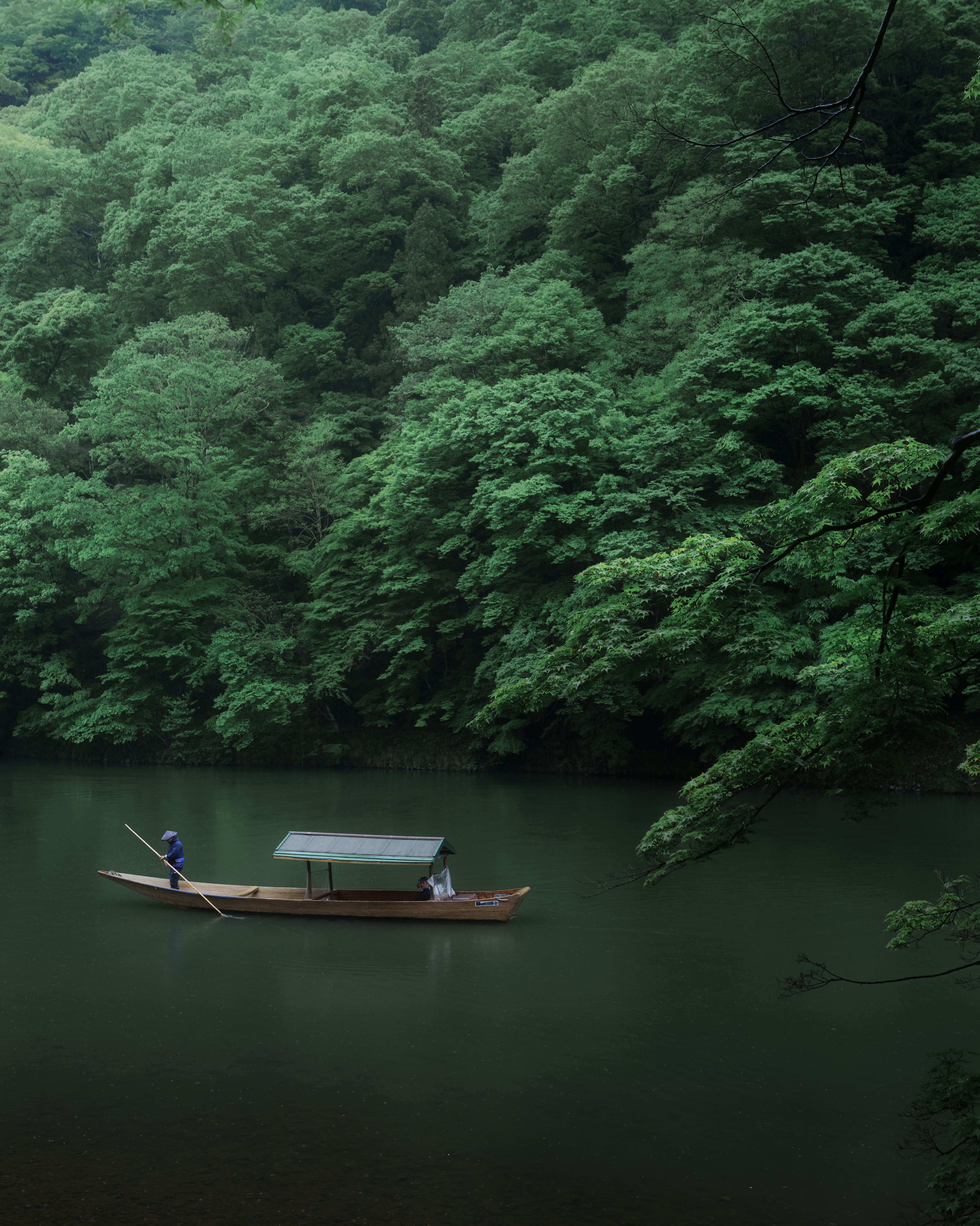 une rivière calme avec une petite barque entourée d’une forêt luxuriante