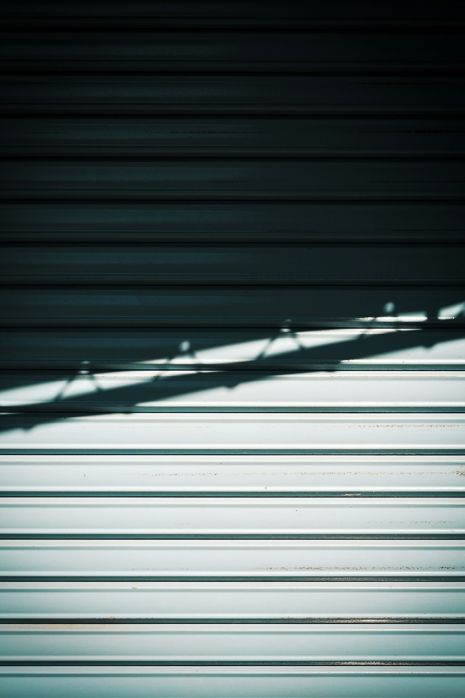 Ombre d'un volet sur une surface métallique