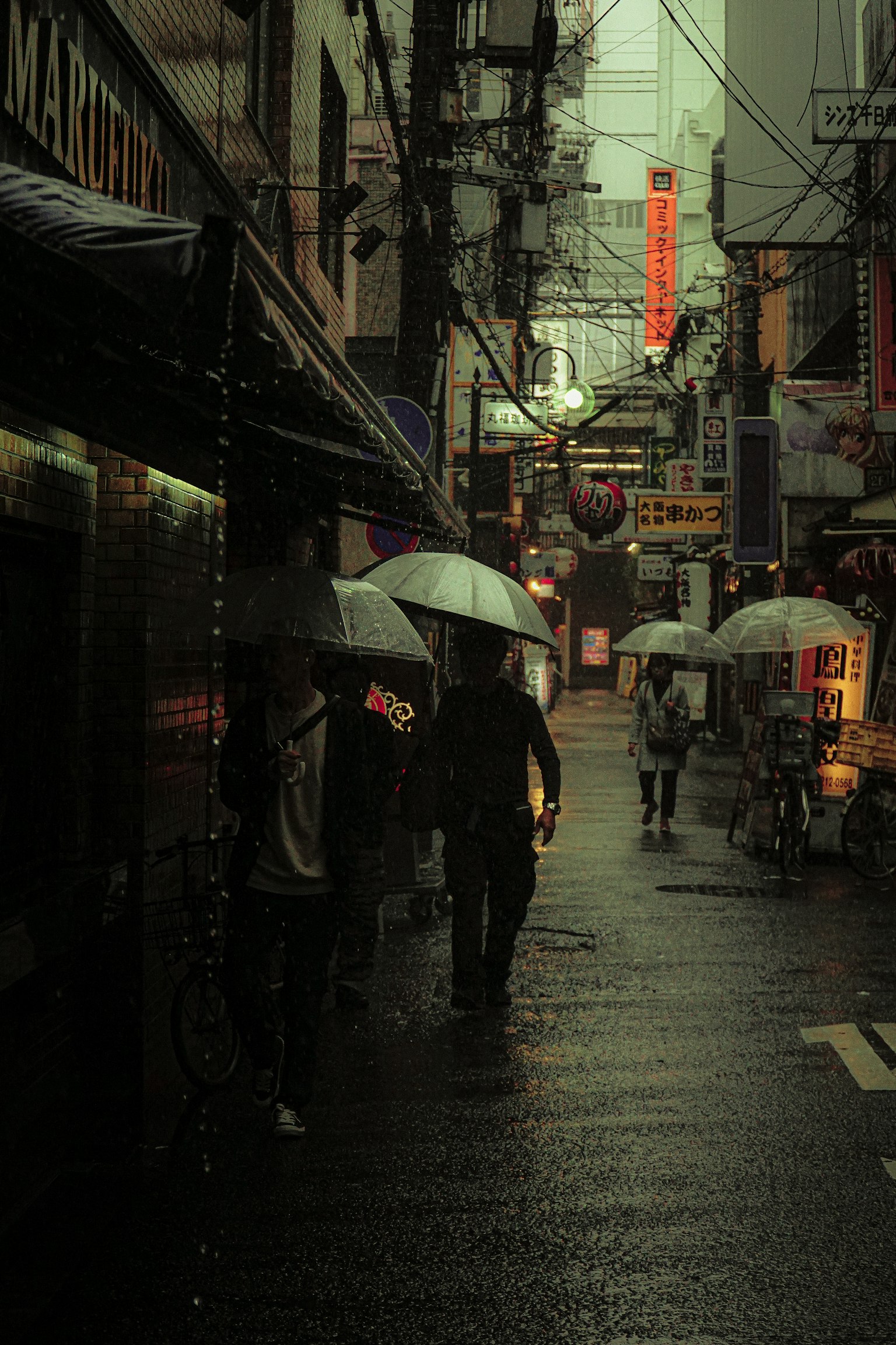 비 오는 거리에서 우산을 쓴 사람들