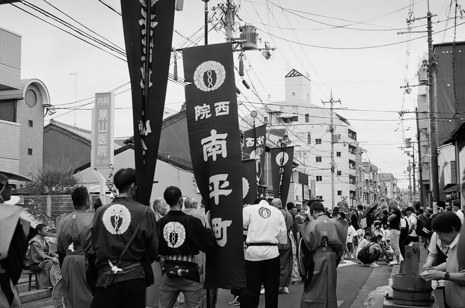 Ảnh đen trắng về một cuộc diễu hành lễ hội trên đường những người tham gia trong trang phục truyền thống