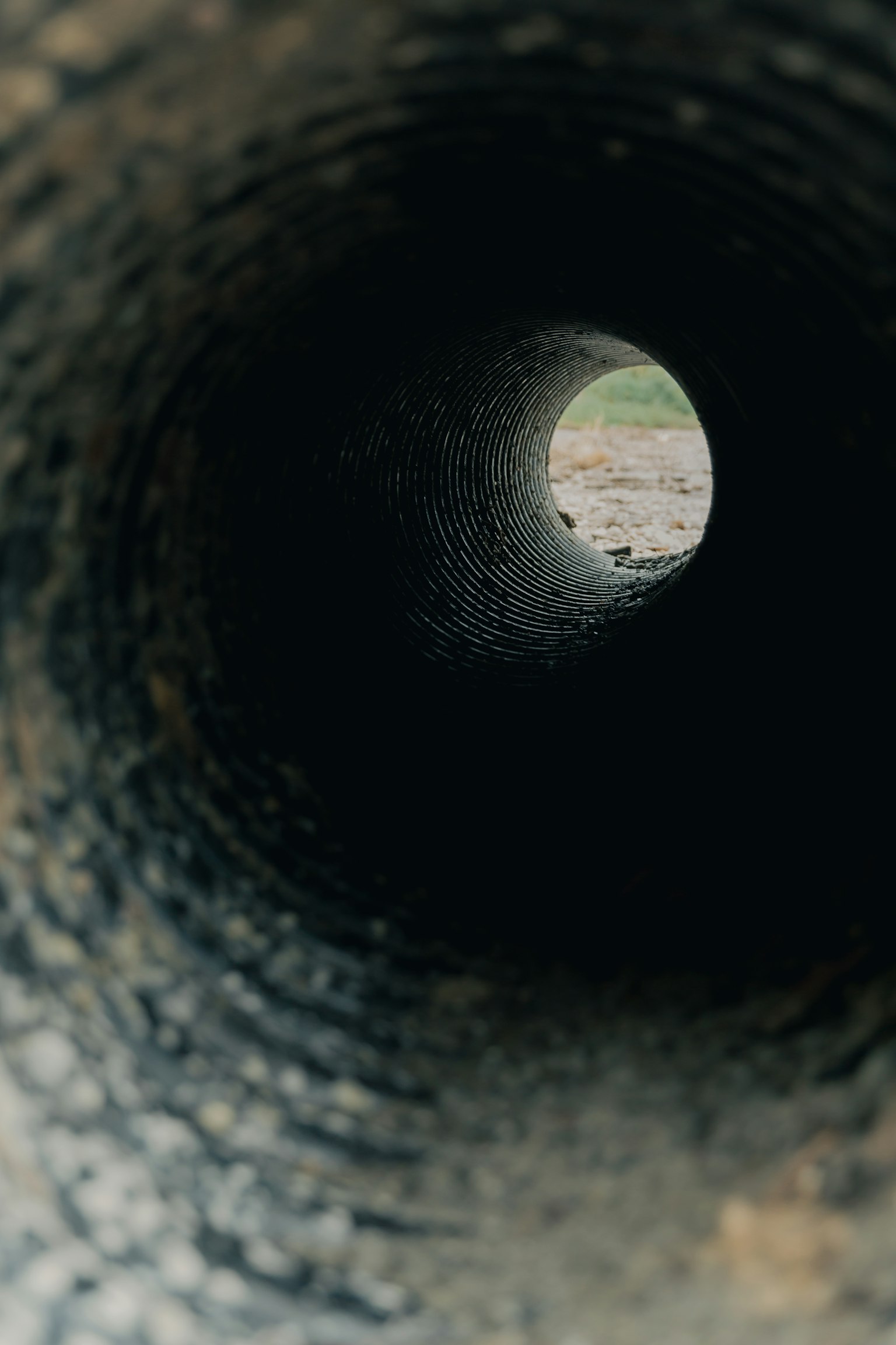 View through a pipe showing green grass outside