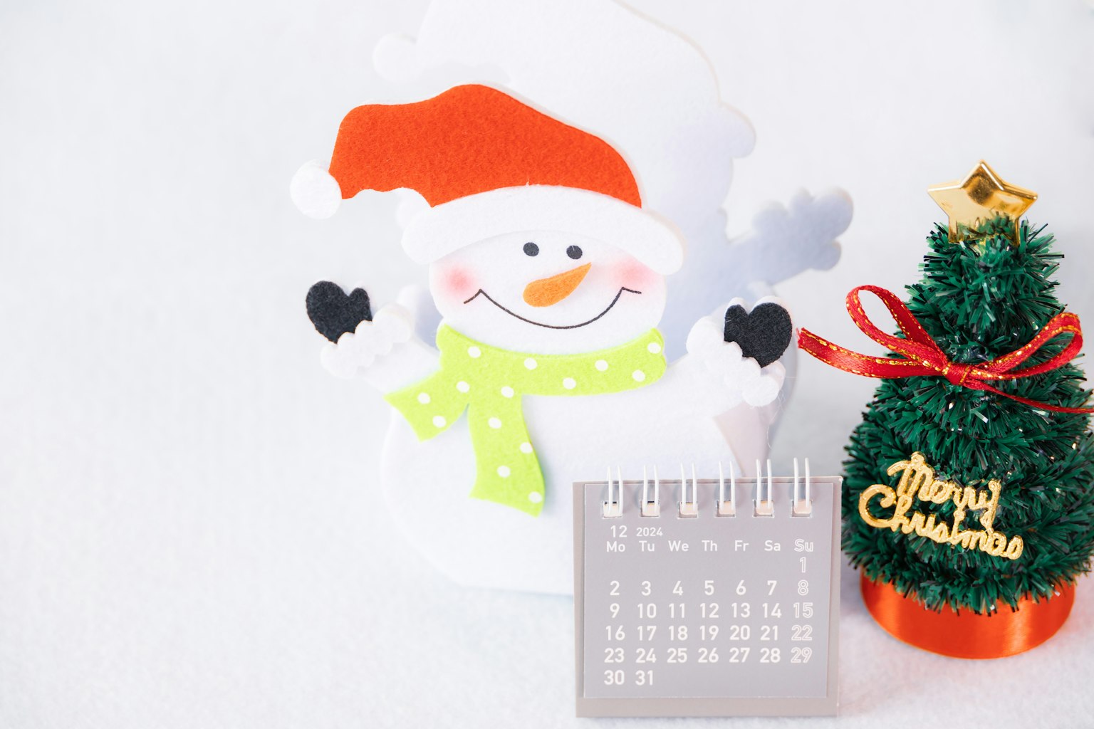 Eine fröhliche Weihnachtsdekoration mit einem Schneemann, einem Weihnachtsbaumornament und einem Kalender