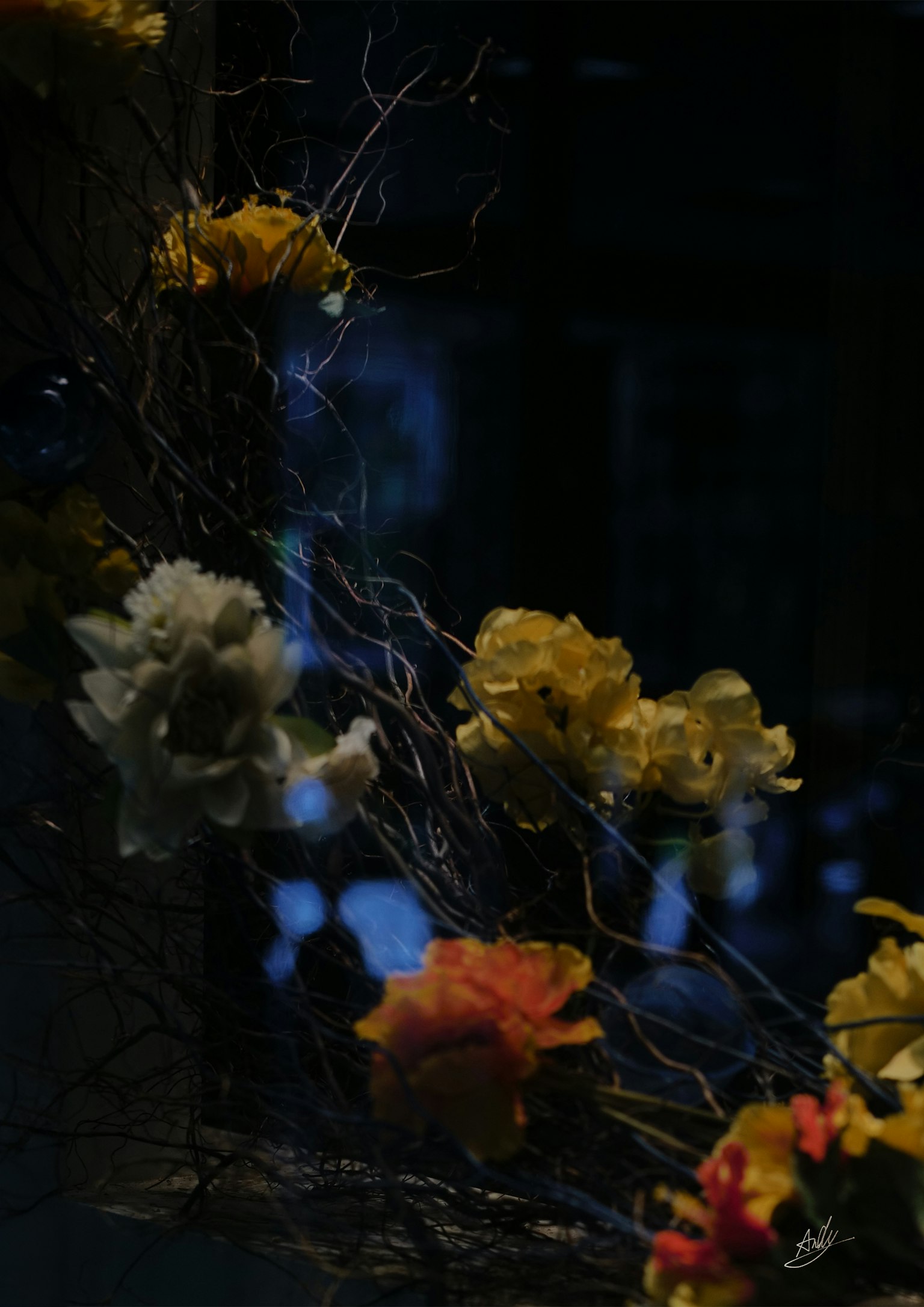 Colorful flower arrangement with branches against a dark background