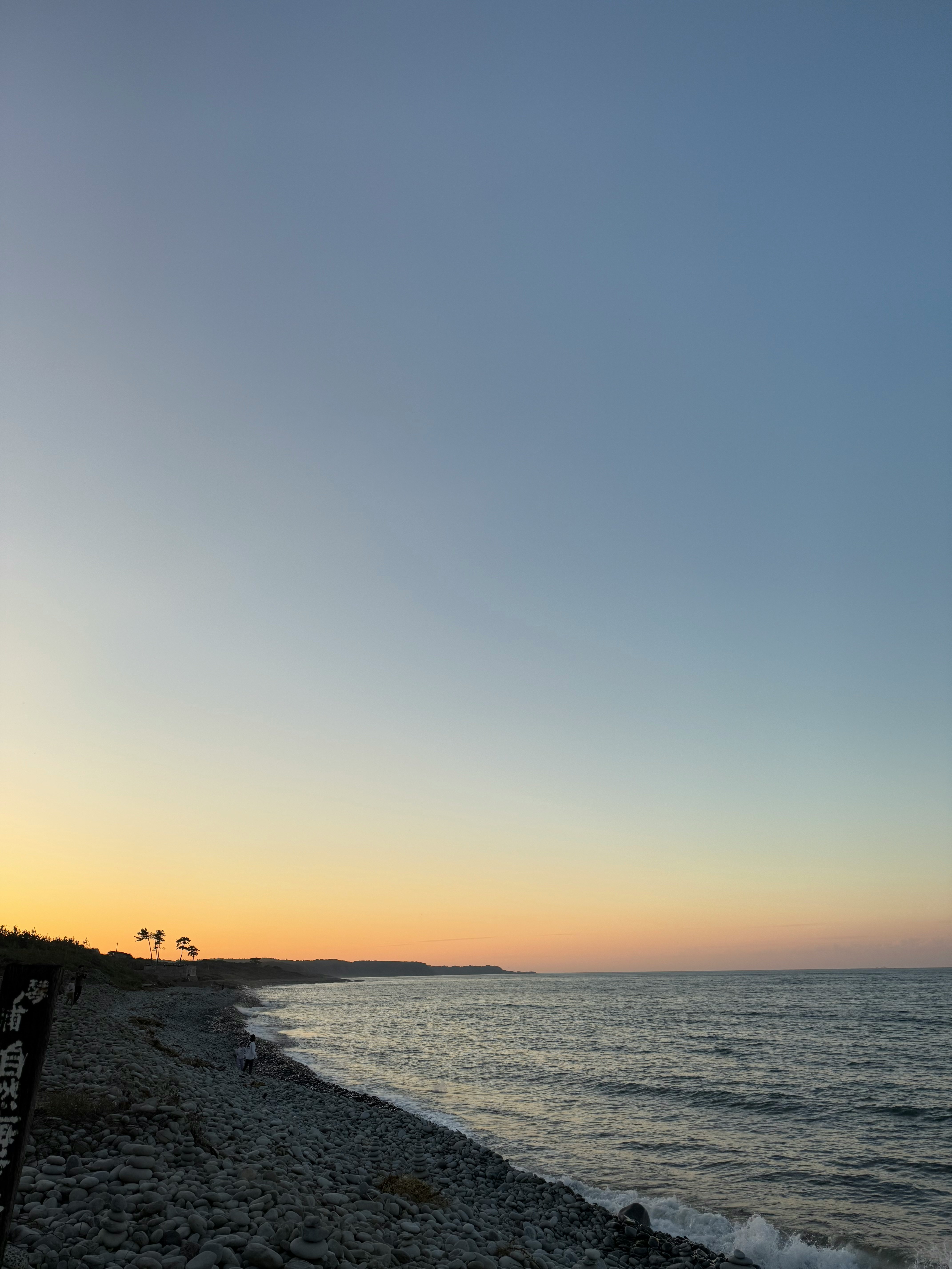 夕焼けの海辺の砂浜と水平線