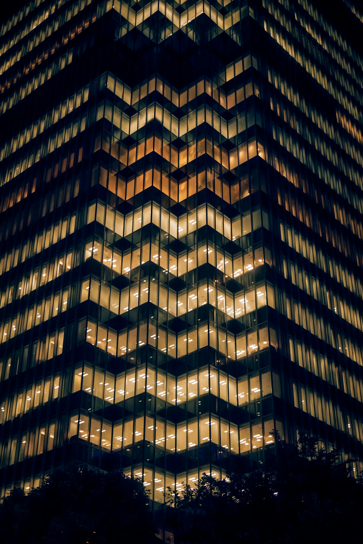 夜间建筑外观带有锯齿形图案的照明窗户