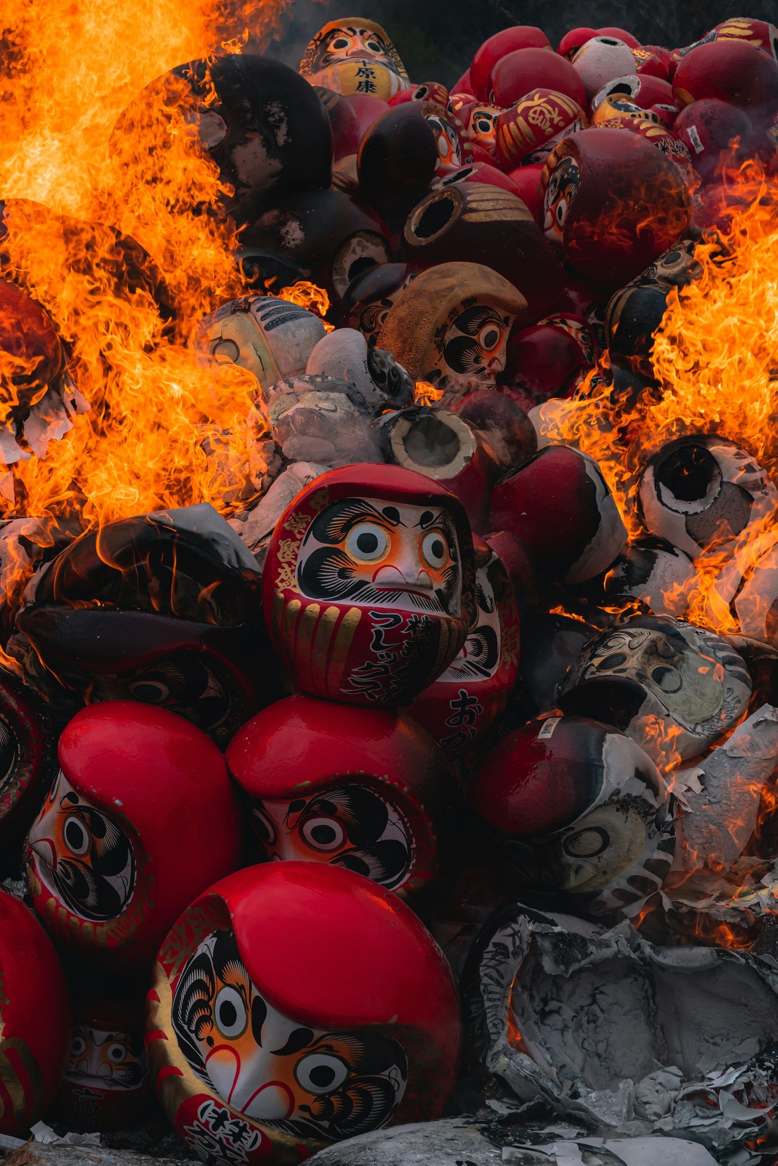 Ein Stapel Daruma-Puppen in Flammen