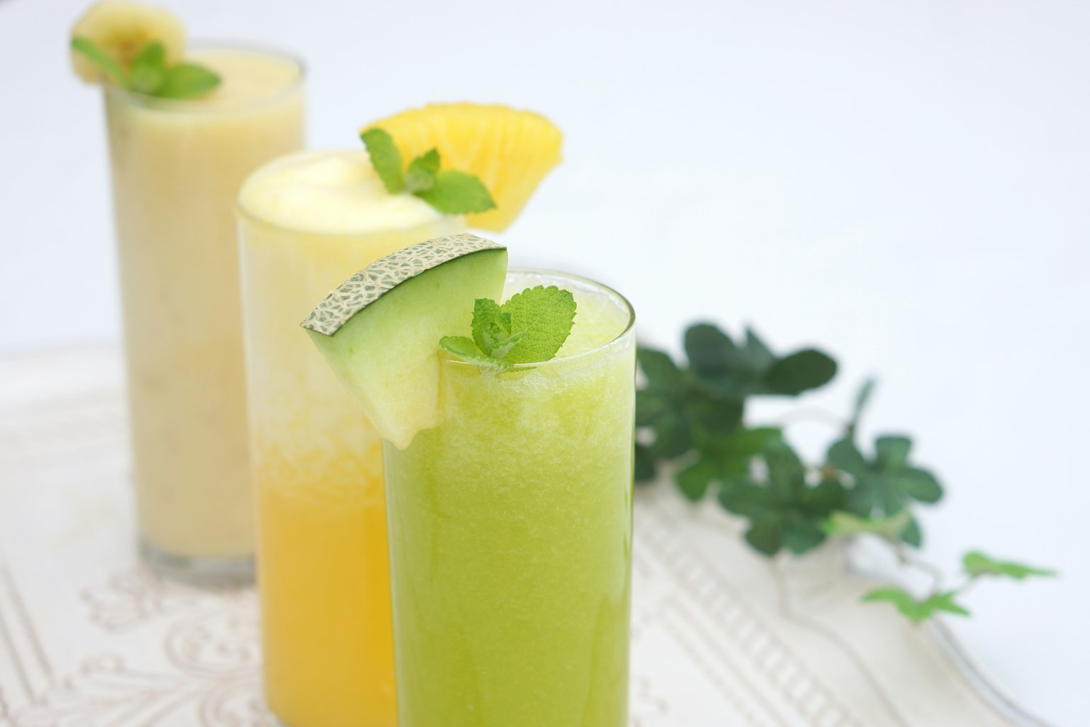 Hình ảnh có ba loại sinh tố trái cây màu sắc được sắp xếp trong ly cao