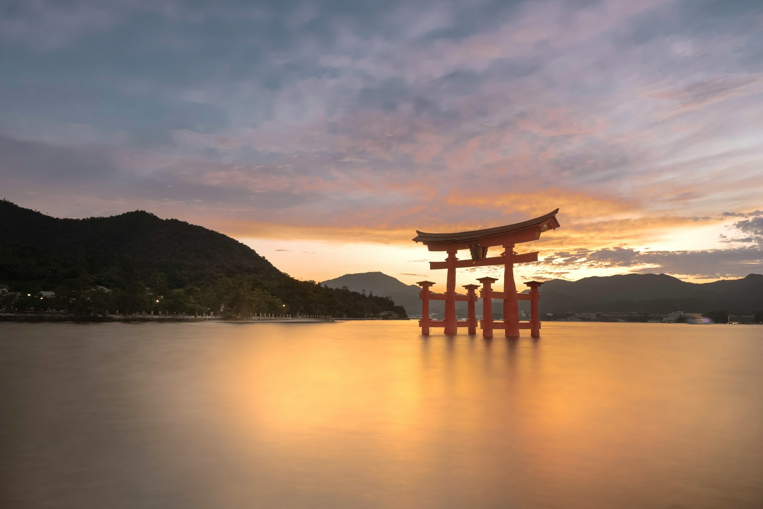 Torii del santuario de Itsukushima en el agua durante el atardecer