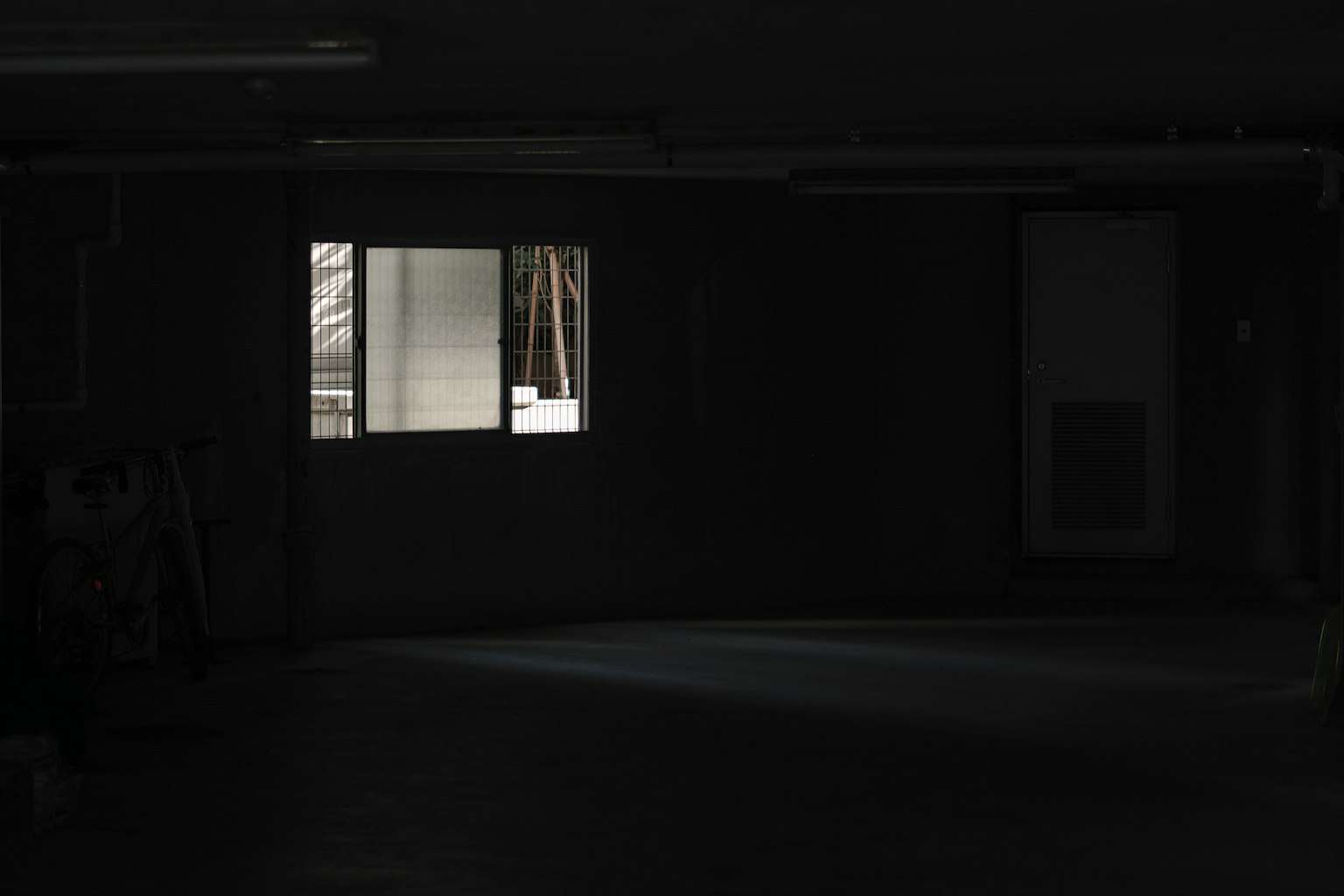 Dimly lit room with a bright window illuminating the space