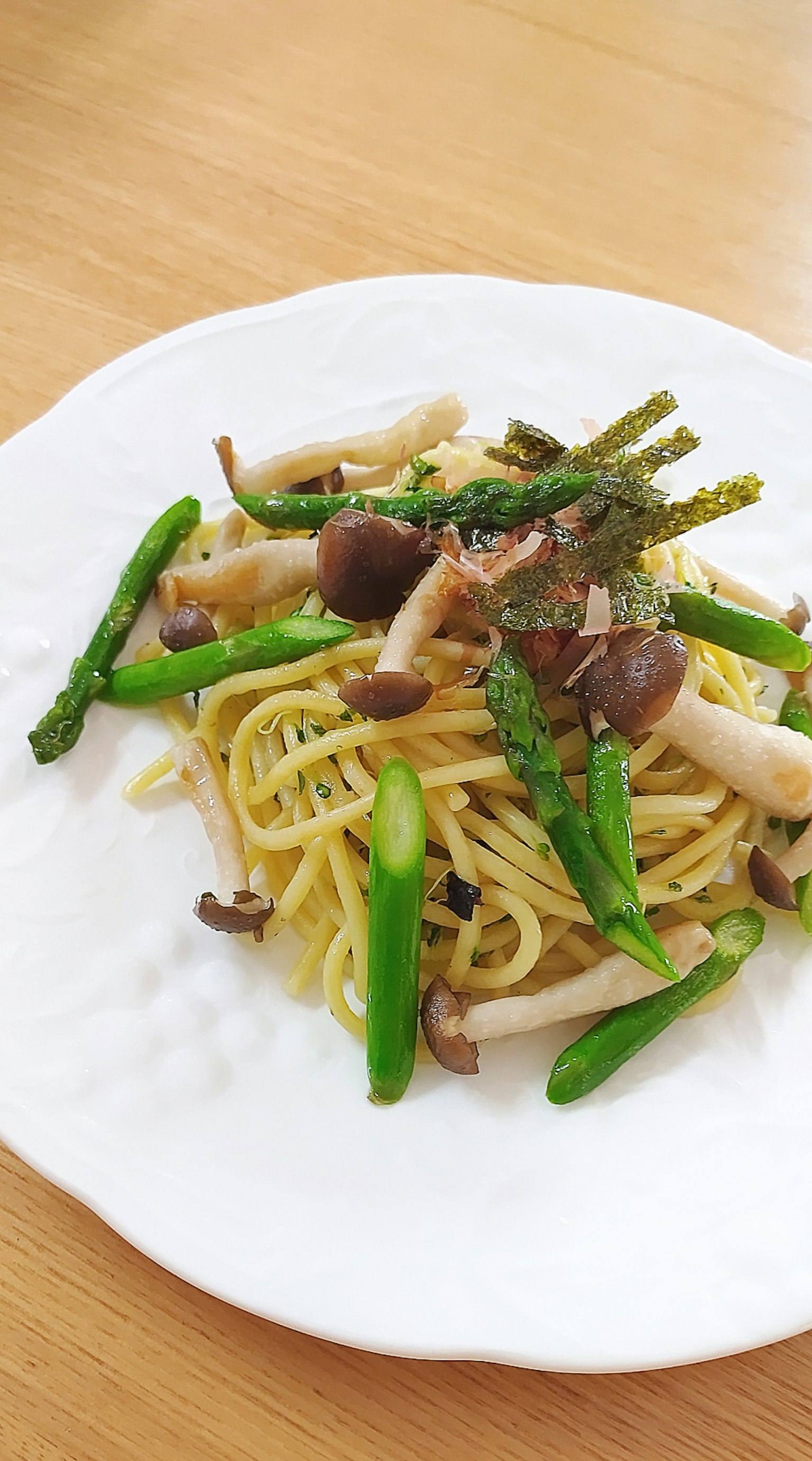 Pastagericht mit grünen Gemüse auf einem weißen Teller serviert