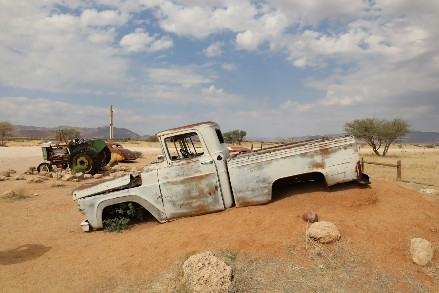 锈迹斑斑的卡车部分埋入沙漠沙中