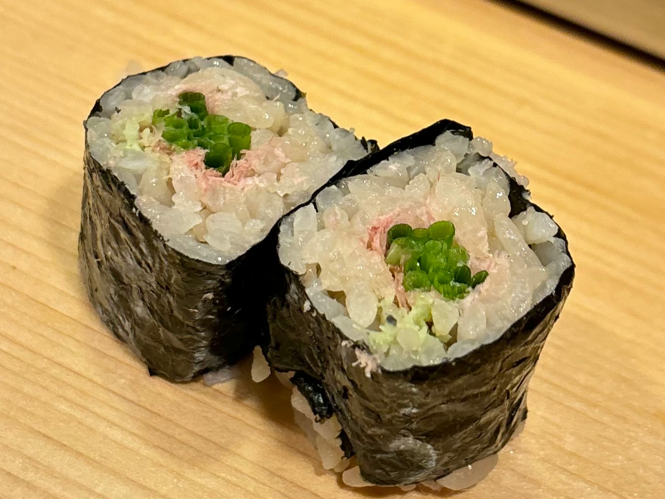 đĩa sushi cuộn nhiều loại trên bàn gỗ