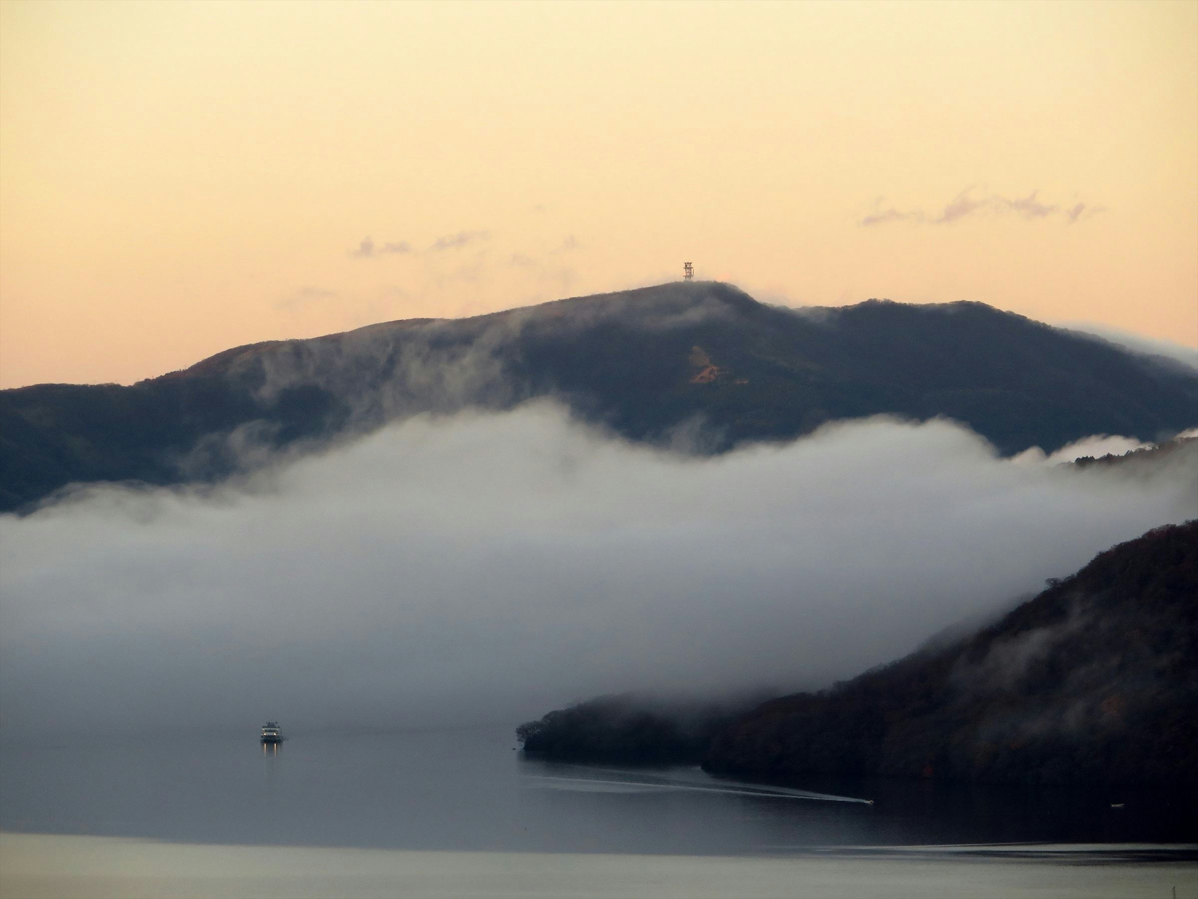 雲海に包まれた山稜と湖の風景