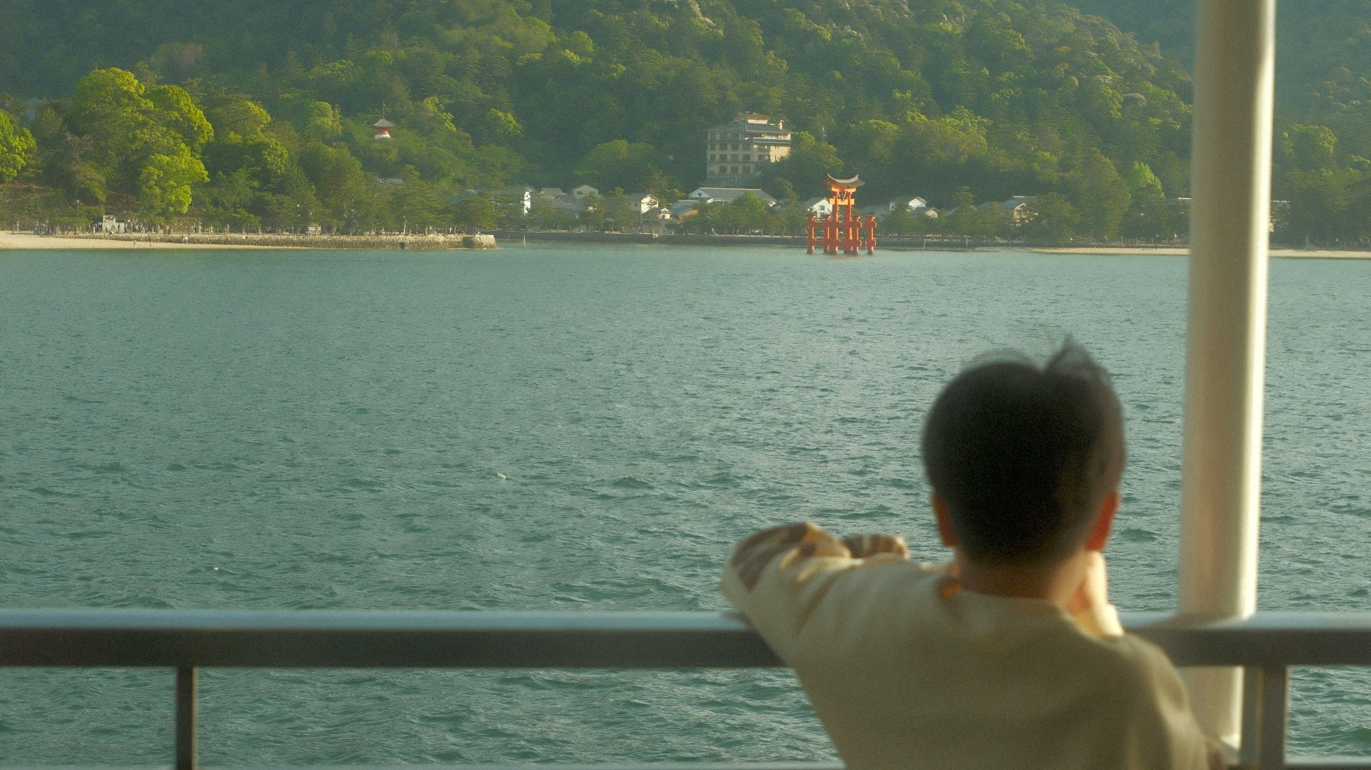 船上から見た湖畔の景色と水上の小舟