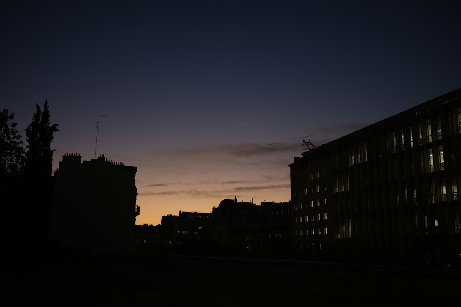 Silhouette of buildings against a twilight sky with colorful sunset hues